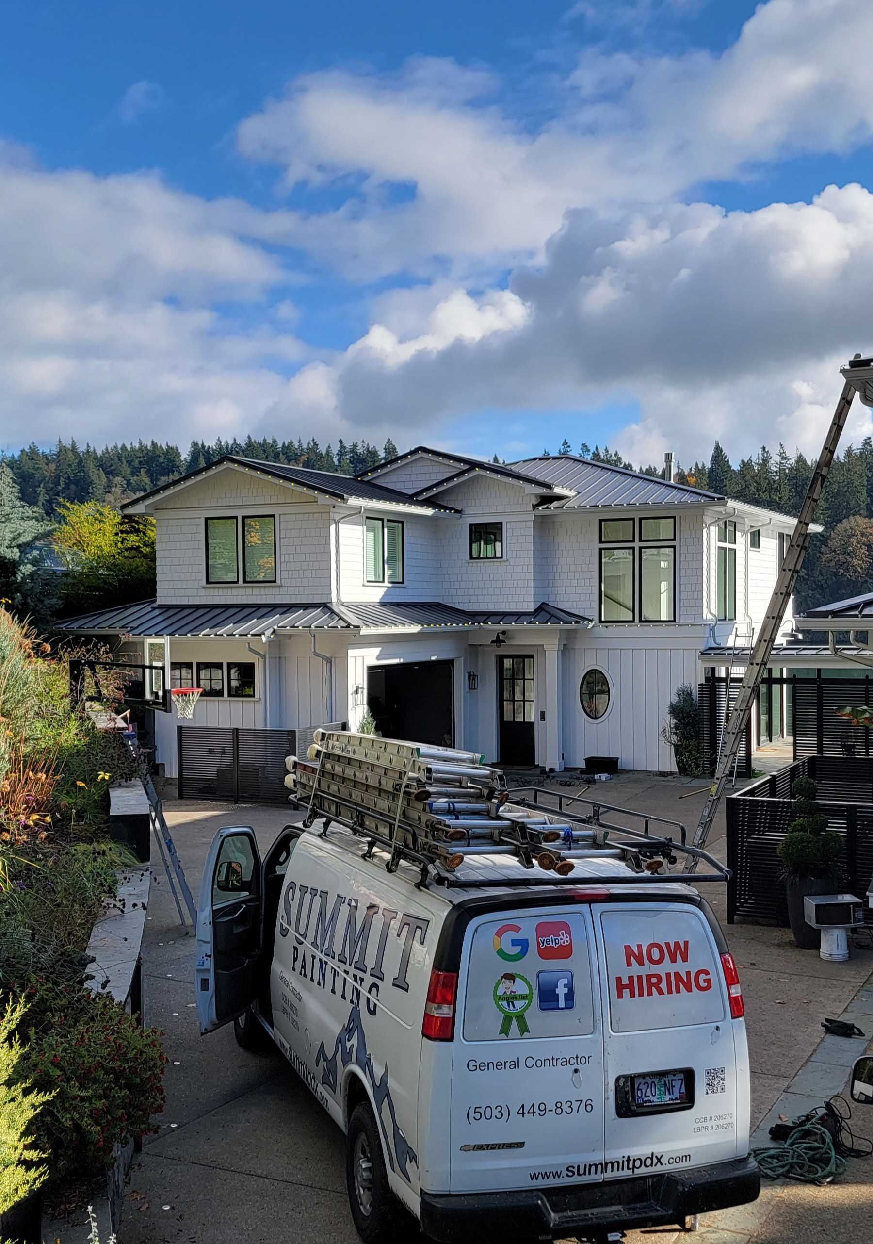 White house with construction van parked in front, clear sky.