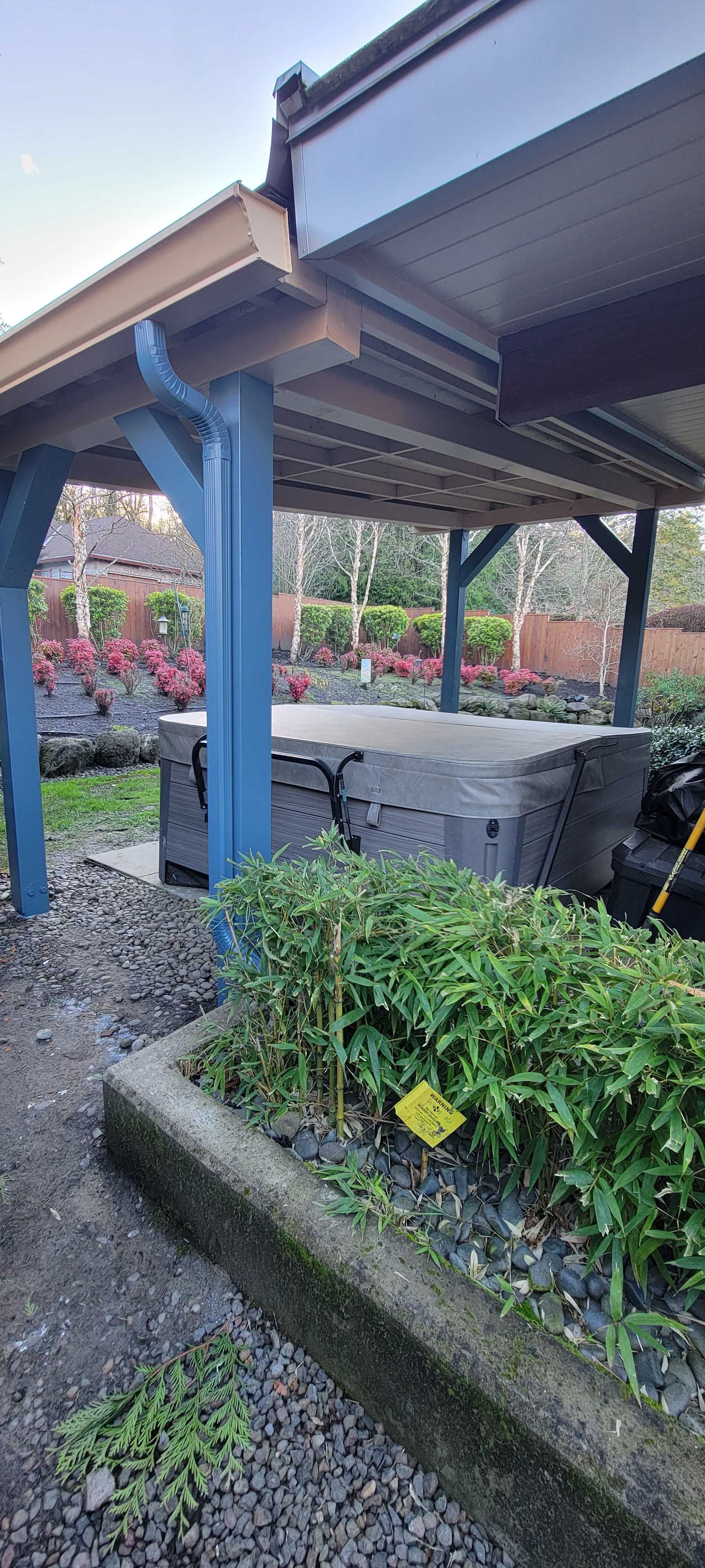 Blue wooden structure with greenery in a garden.