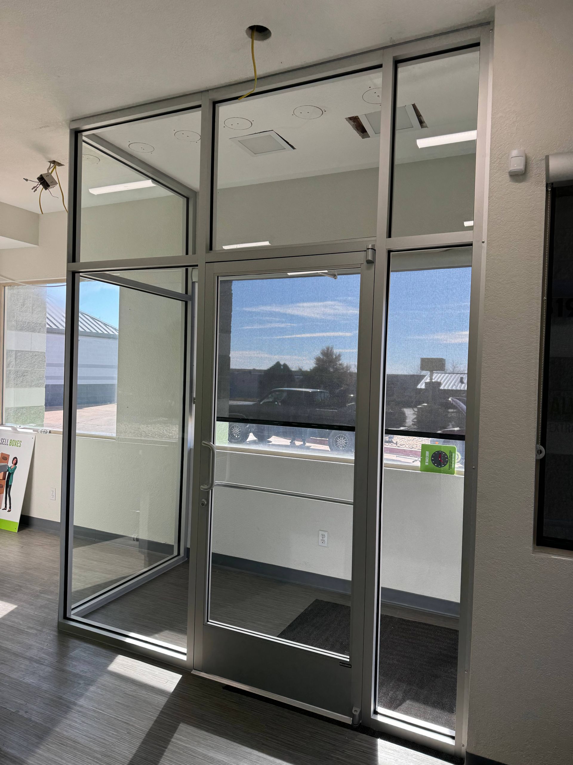 Glass entry door with metal frame, sunny day.