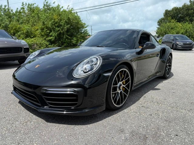 Black Porsche sports car parked outdoors on a sunny day