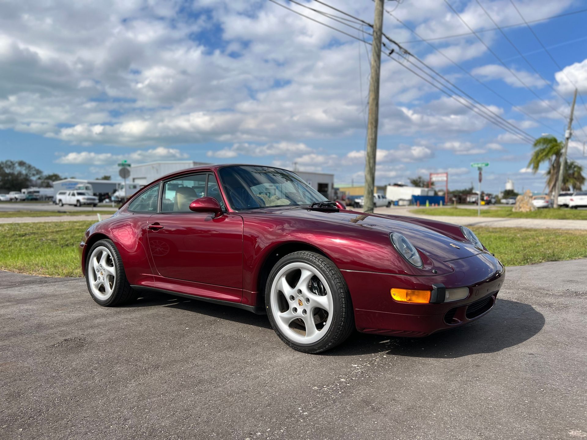 A red porsche 911 is parked on the side of the road.