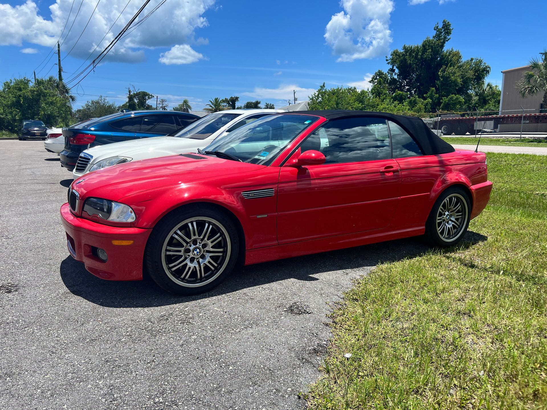 A red bmw m3 convertible is parked in a parking lot.