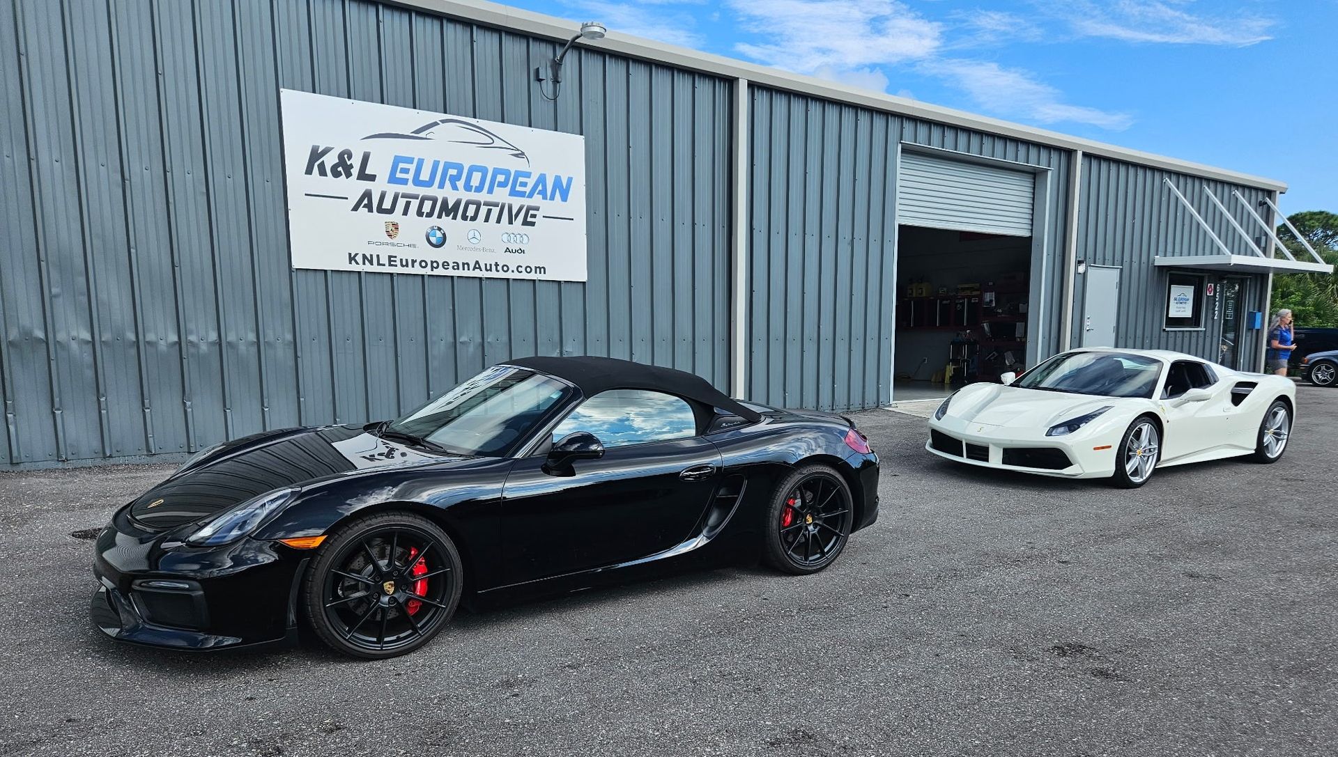 Two sports cars are parked in front of a building.