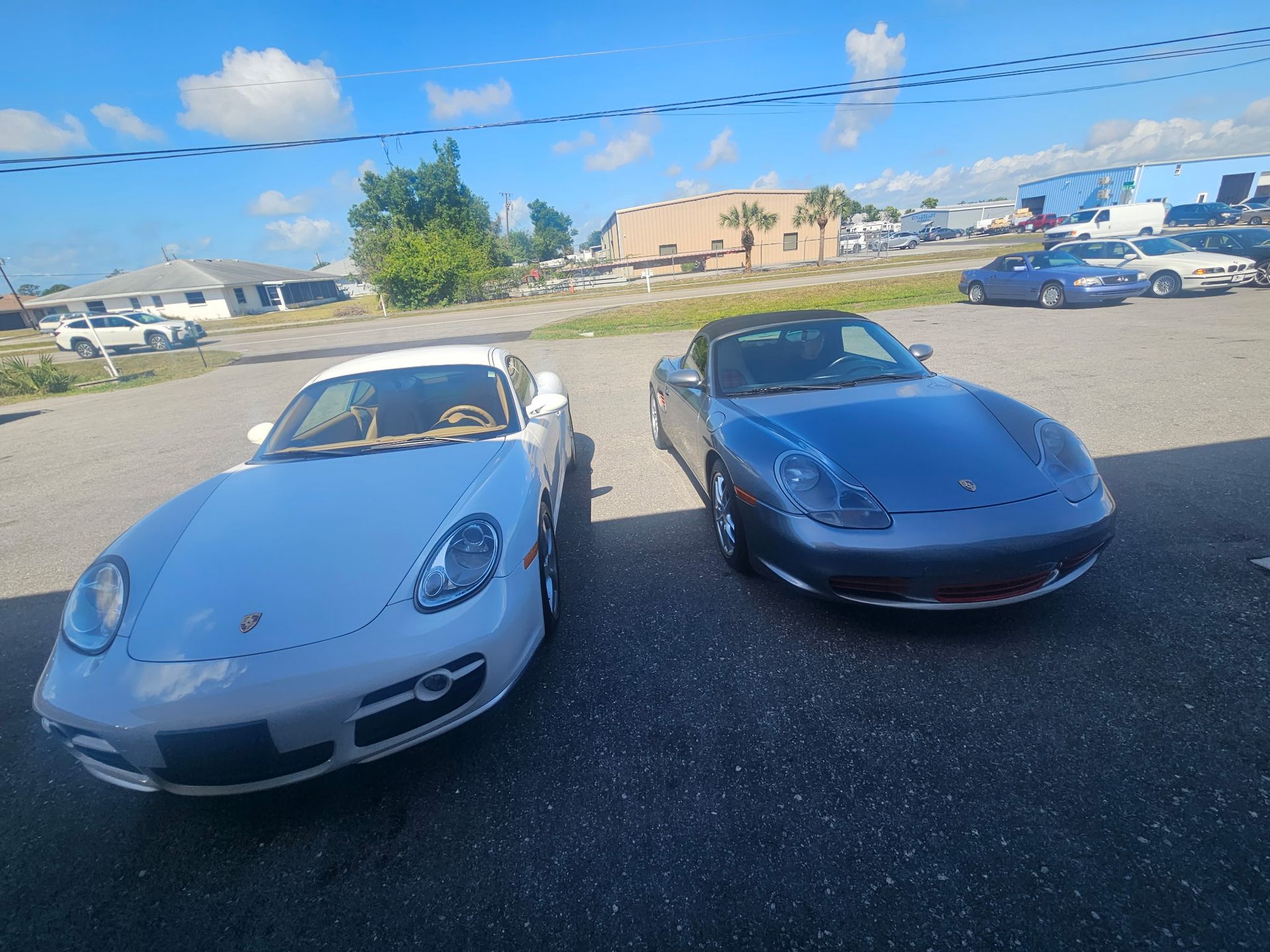 Two sports cars are parked next to each other in a parking lot.