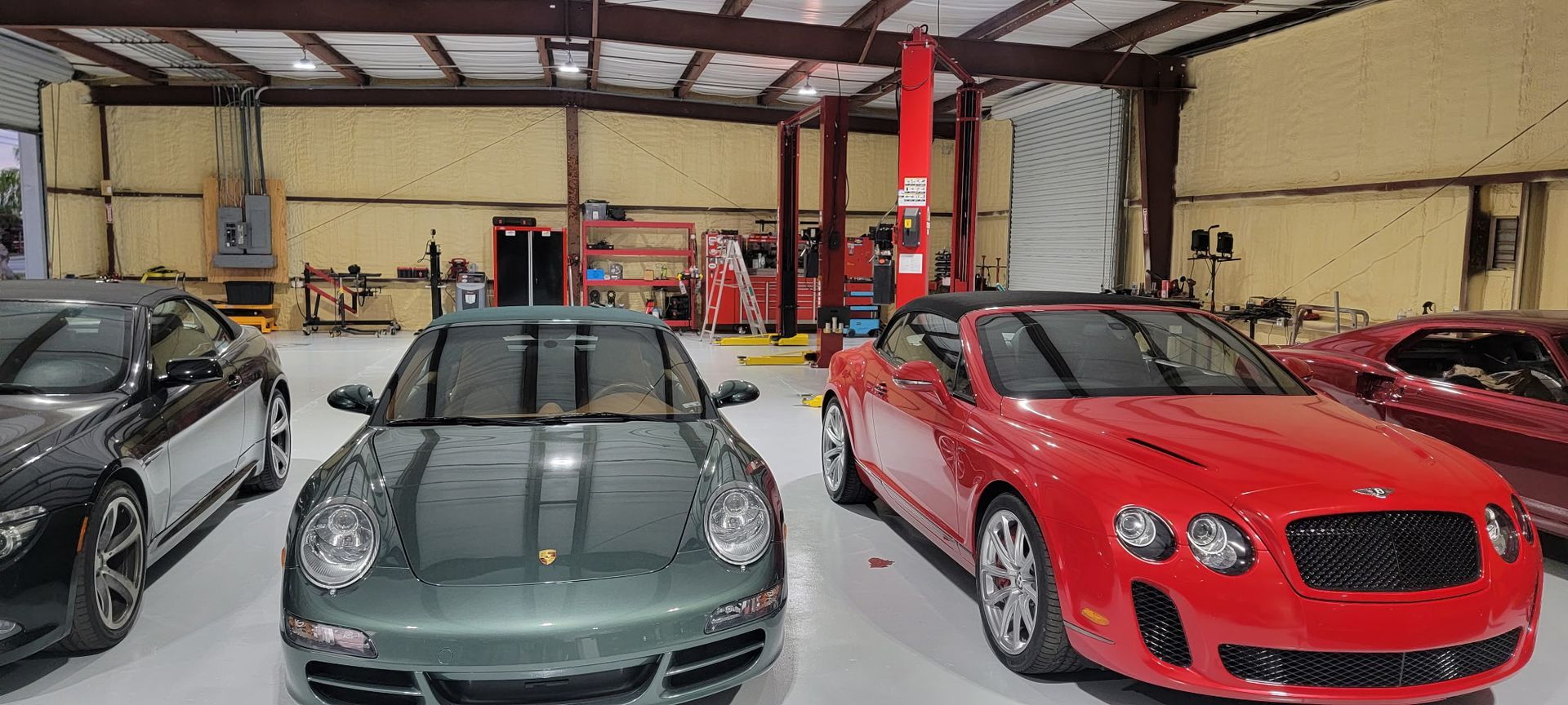 Three sports cars are parked in a garage.