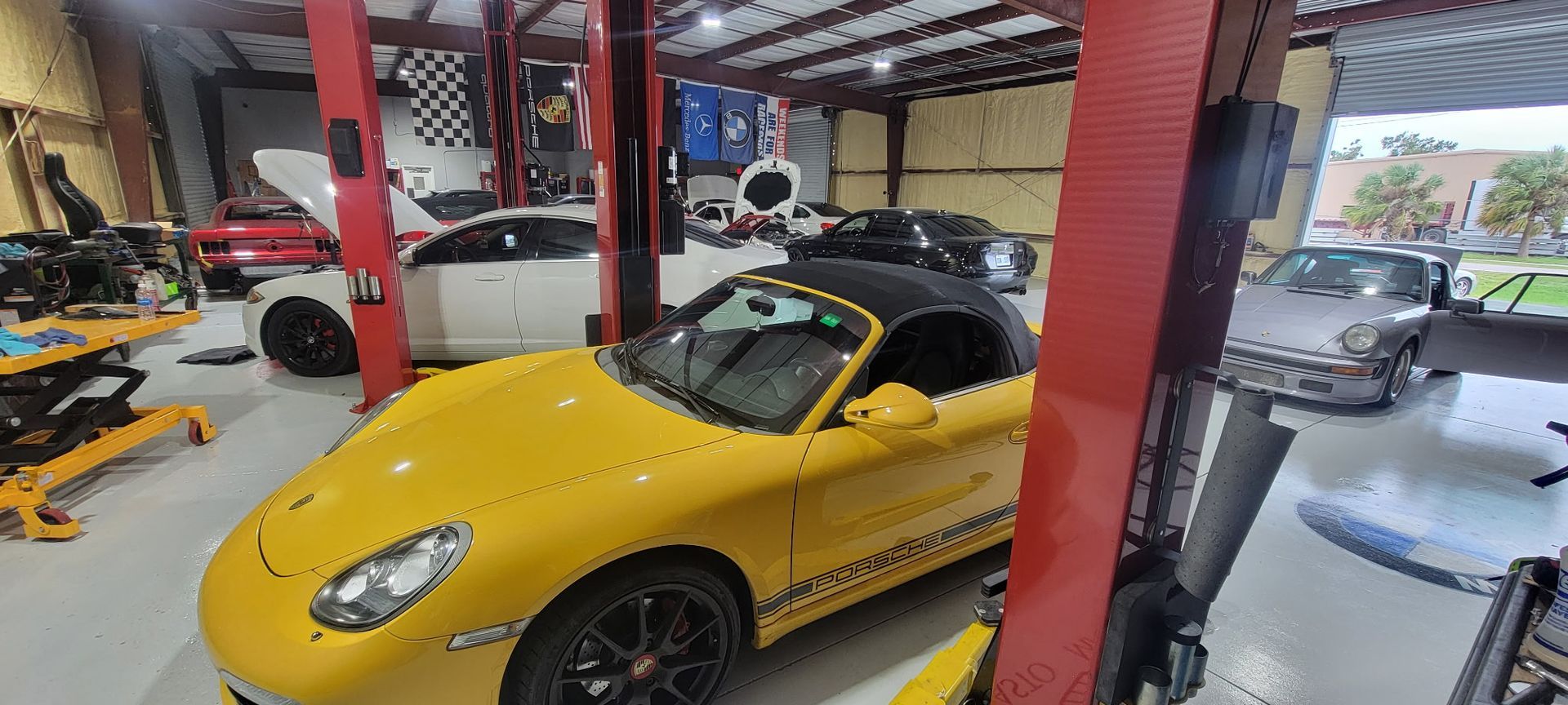 A yellow sports car is parked on a lift in a garage.