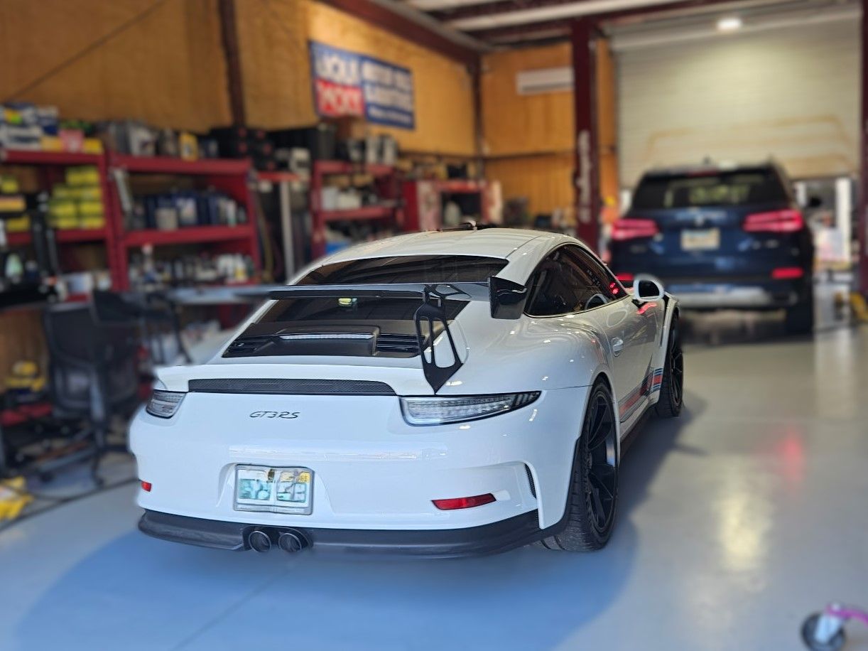 A white sports car is parked in a garage.