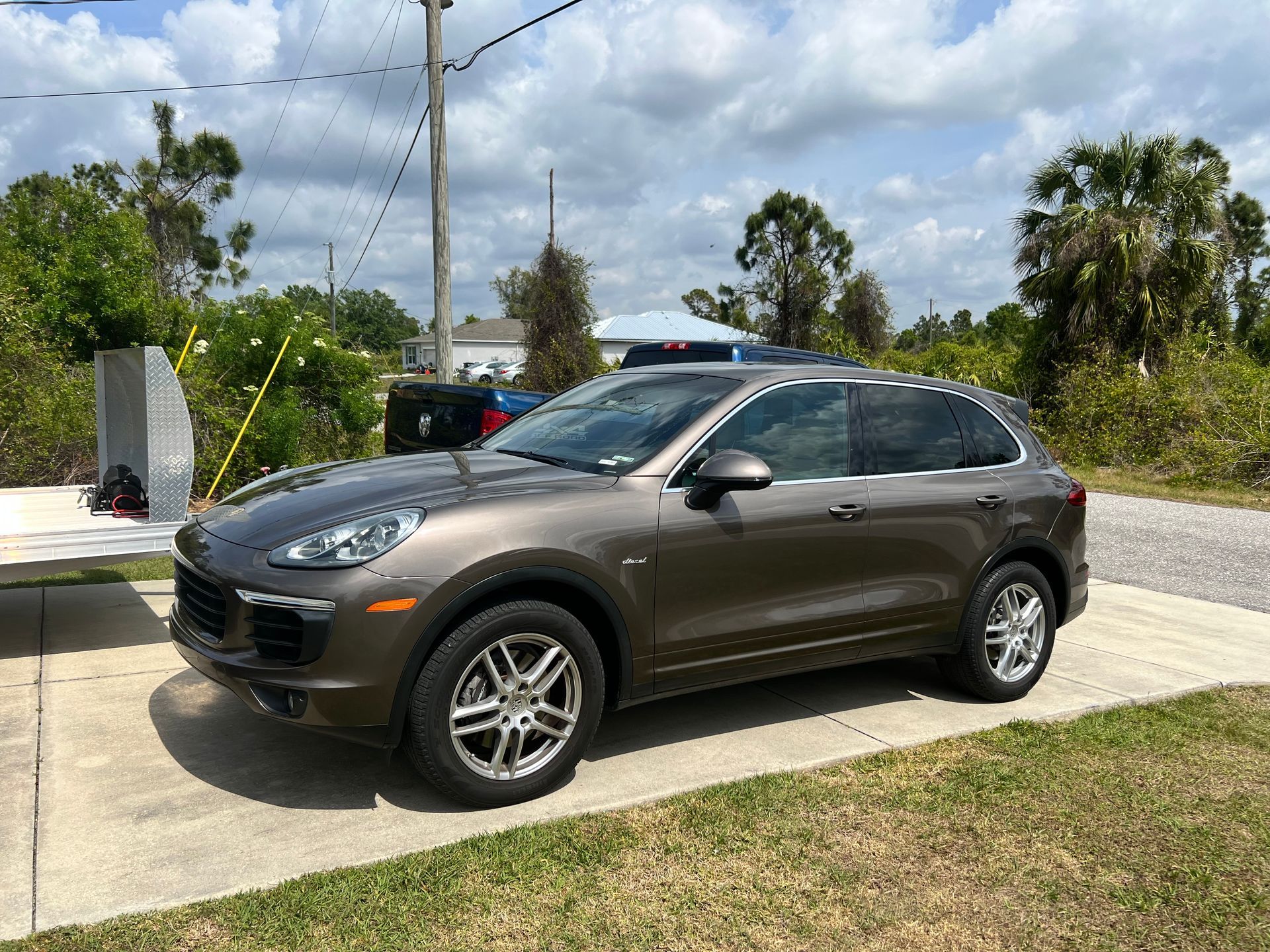 A porsche cayenne is parked on the side of the road.