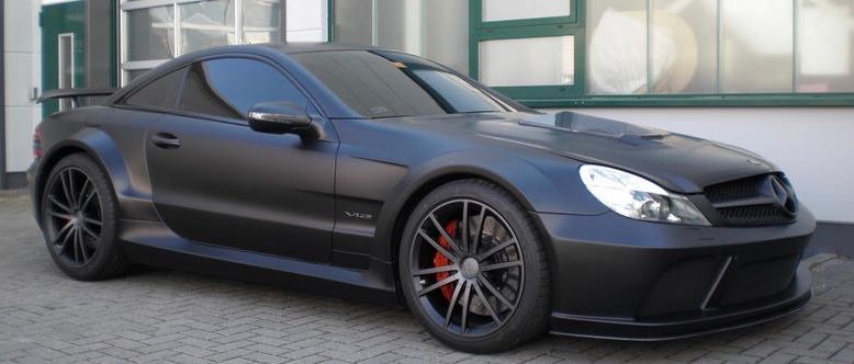 A black sports car is parked in front of a building.