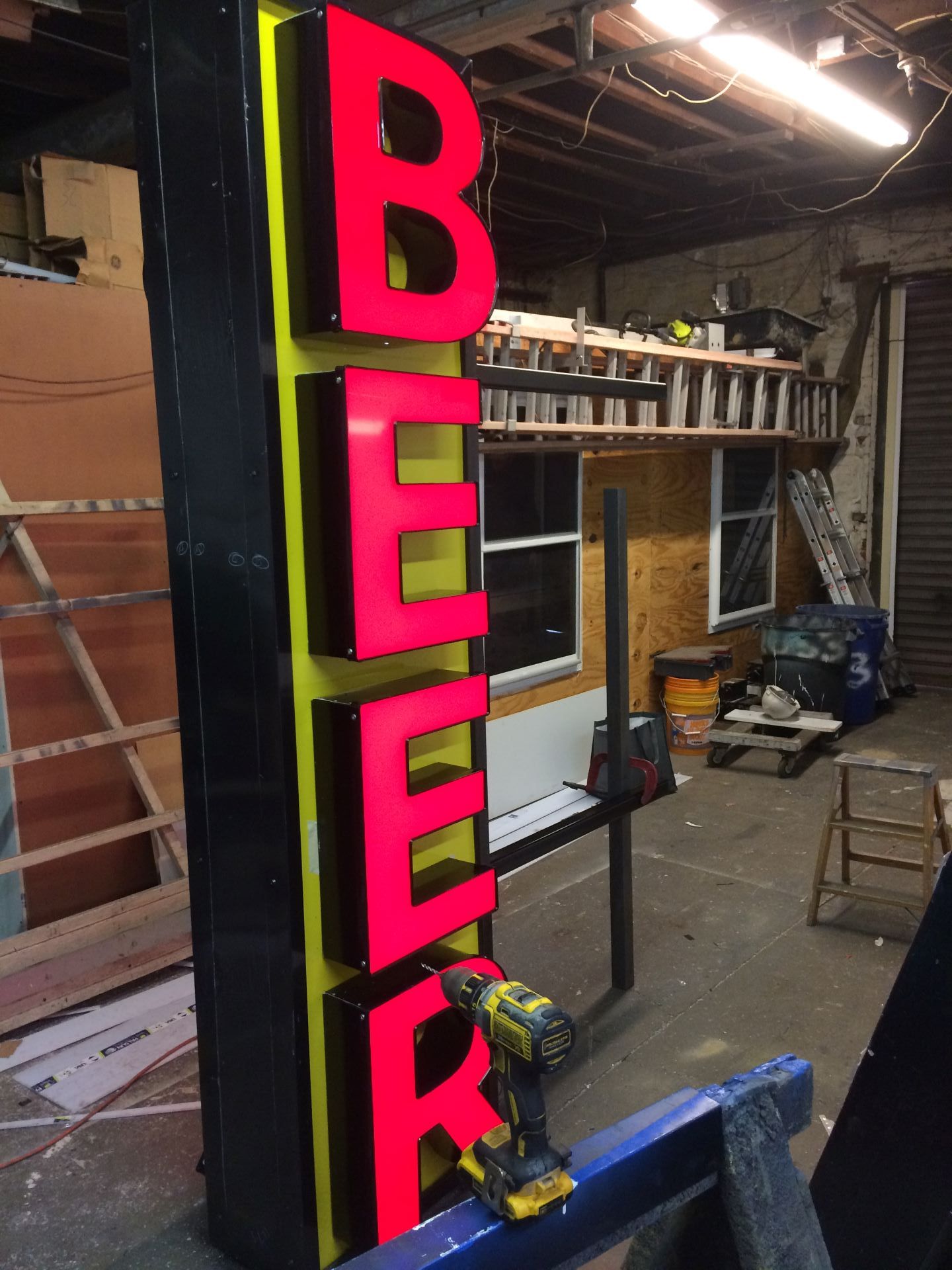 A neon sign that says beer is being built in a garage