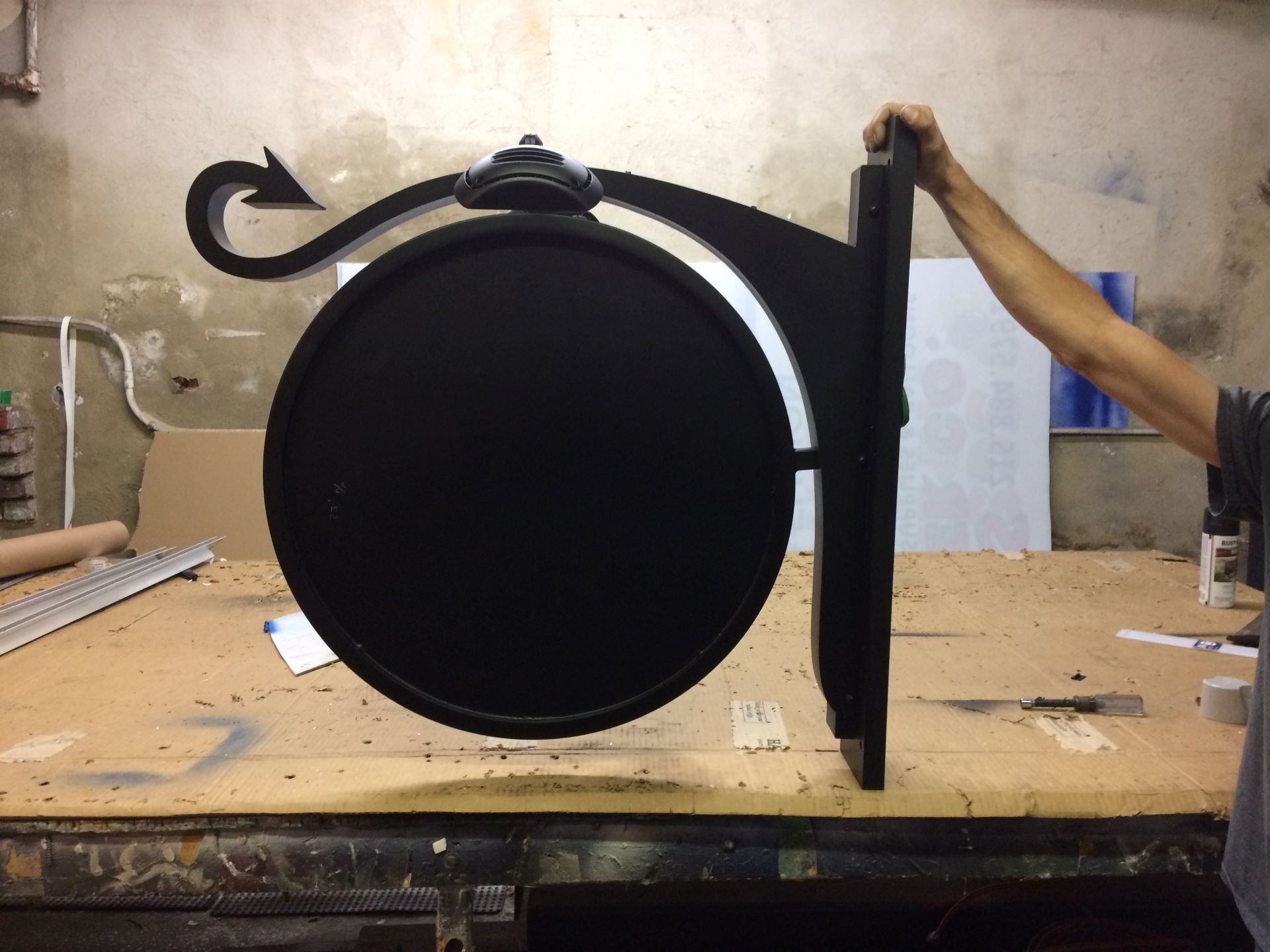 A person is holding a black sign with an arrow on it