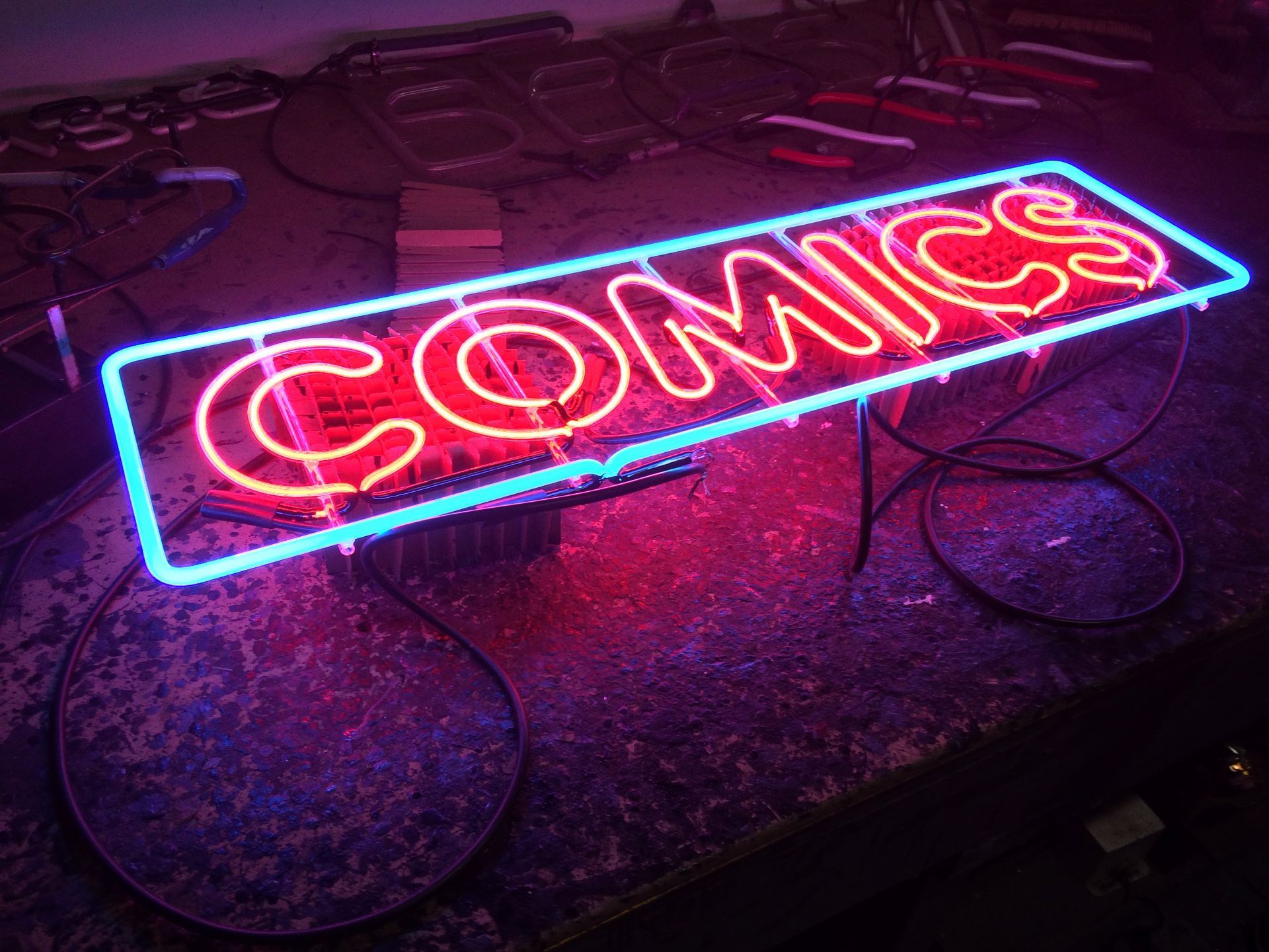 A neon sign that says comics on it