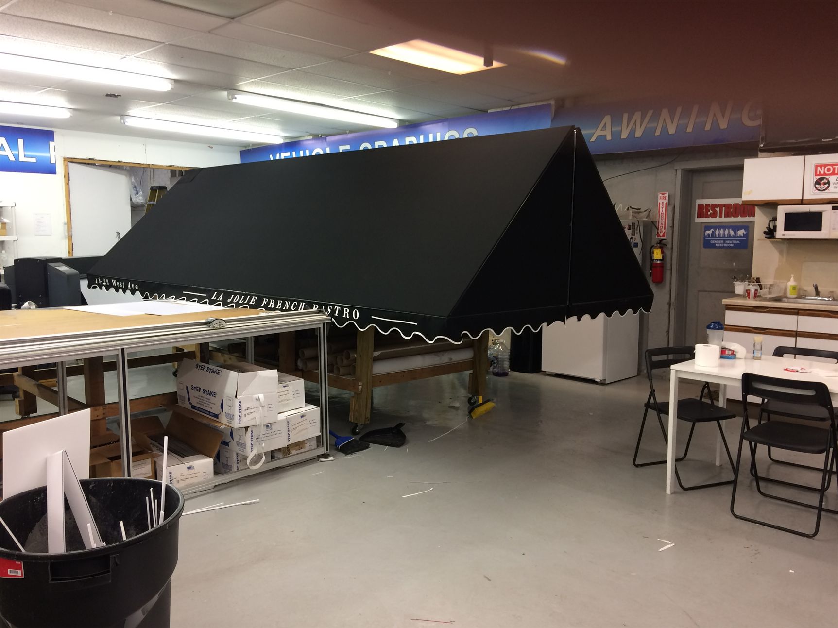 A large black awning is sitting on top of a table in a room.
