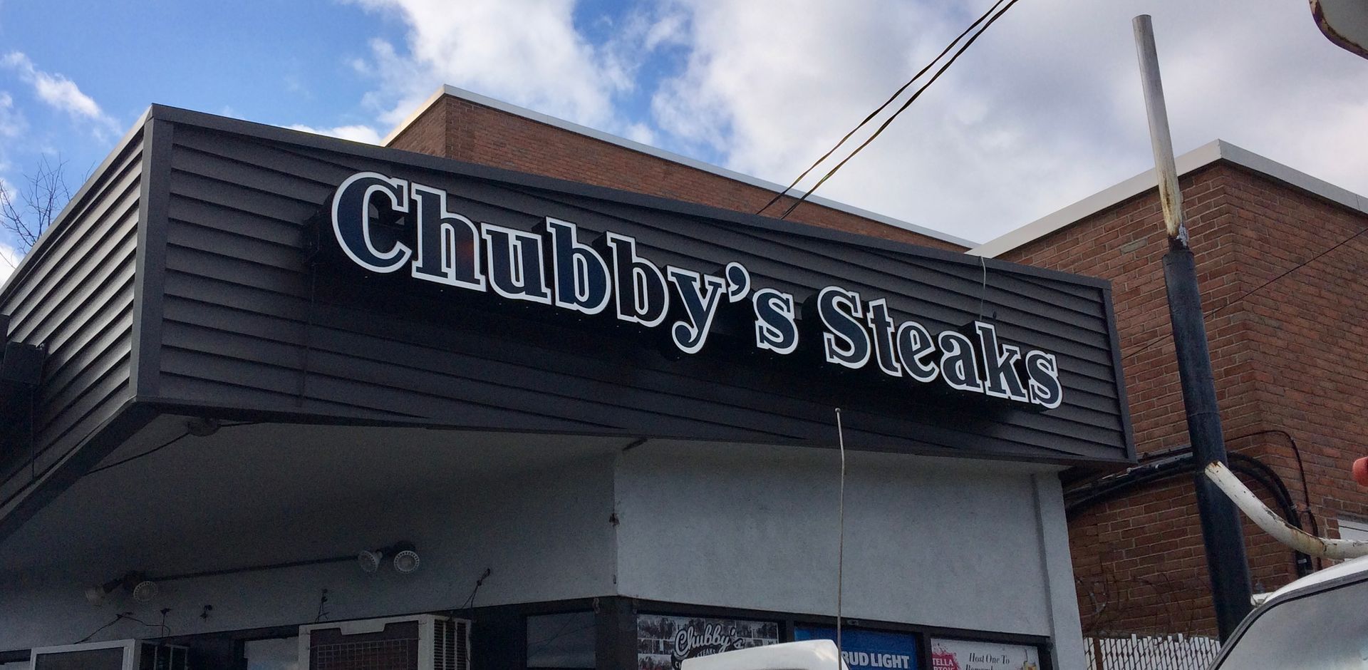 A restaurant called chubby 's steaks is located on a brick building.