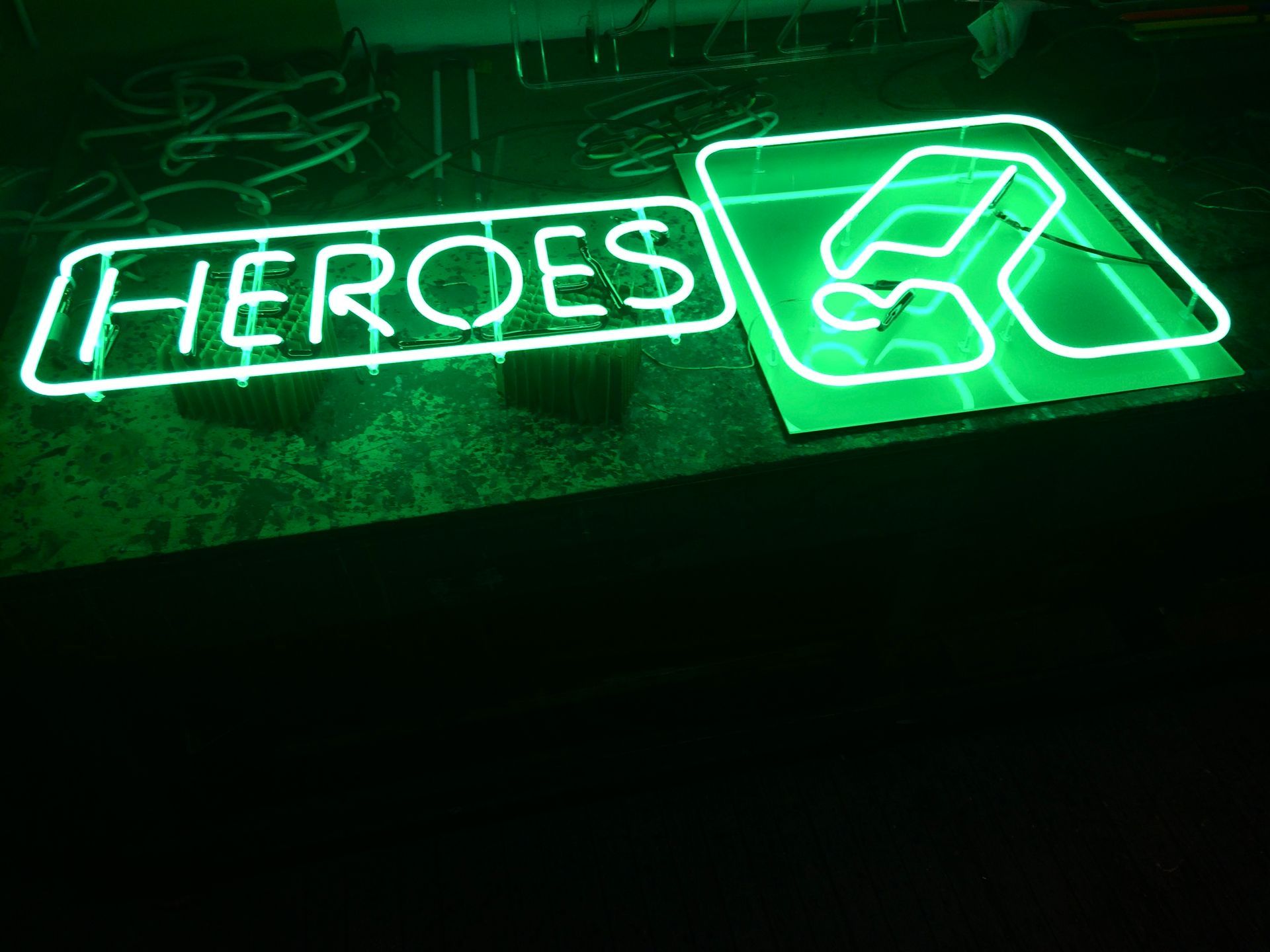 A neon sign that says heroes on it