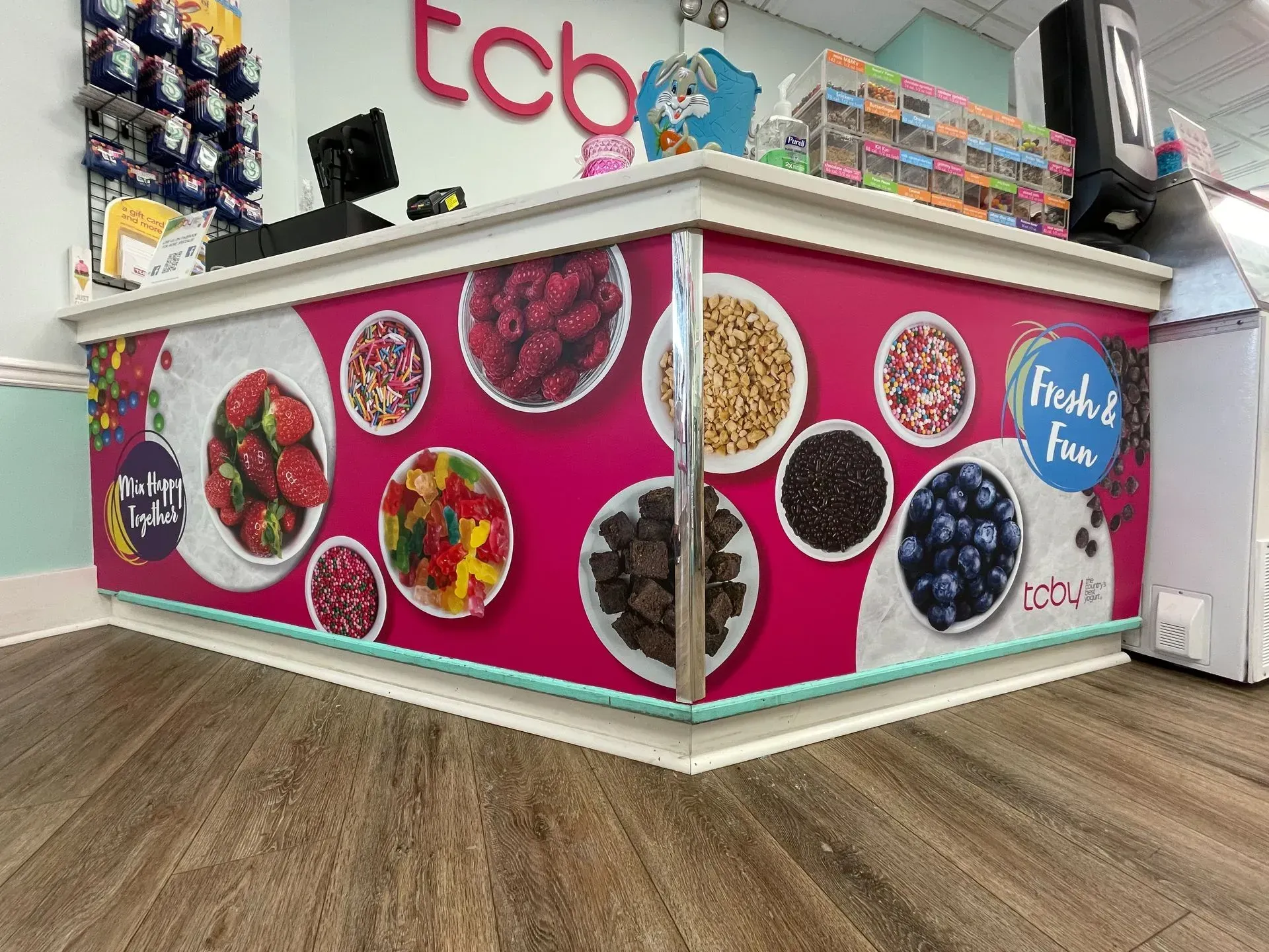 A pink counter with plates of food on it in a store.