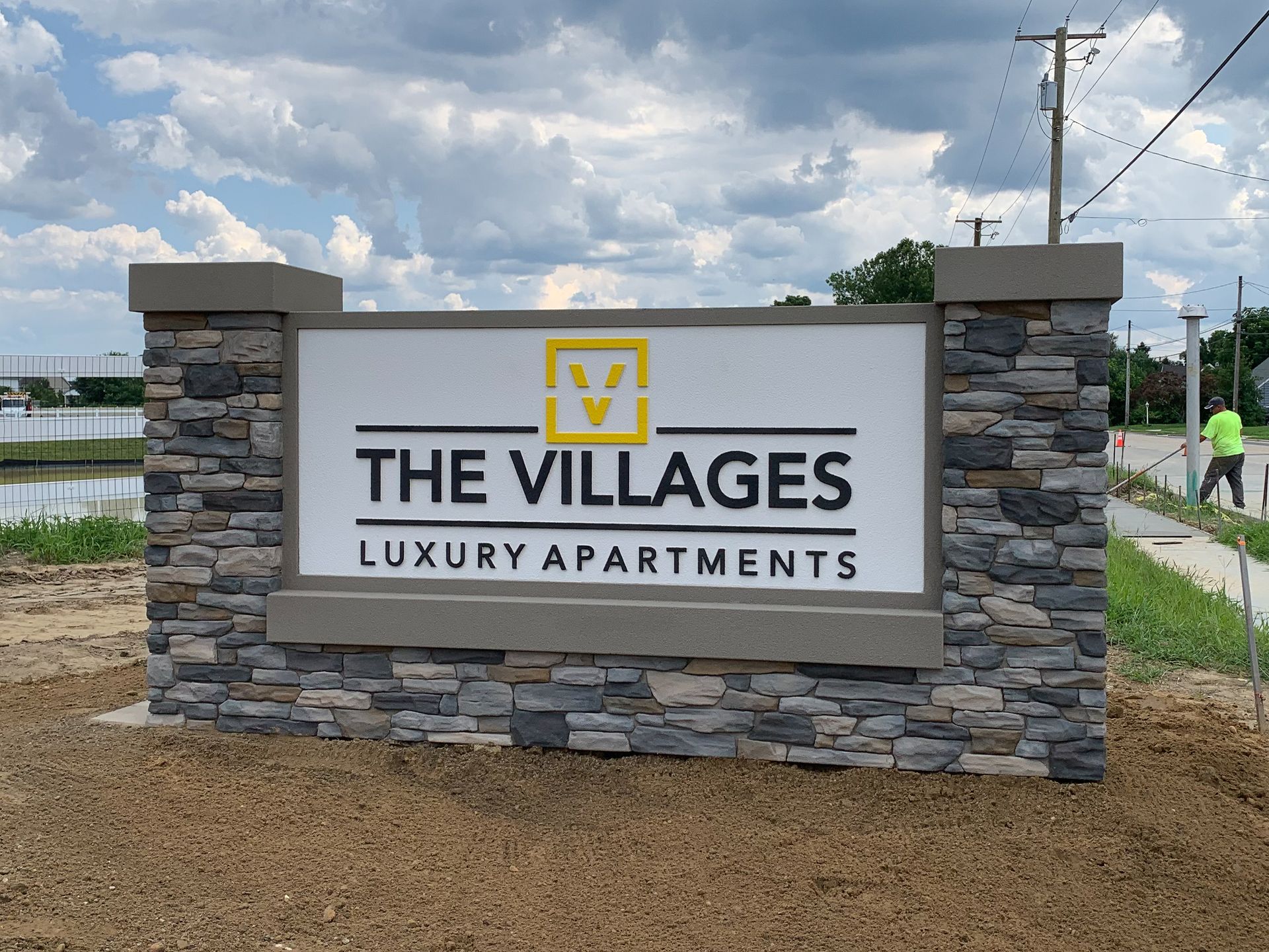 A monument that says The Villages Luxury Apartments.