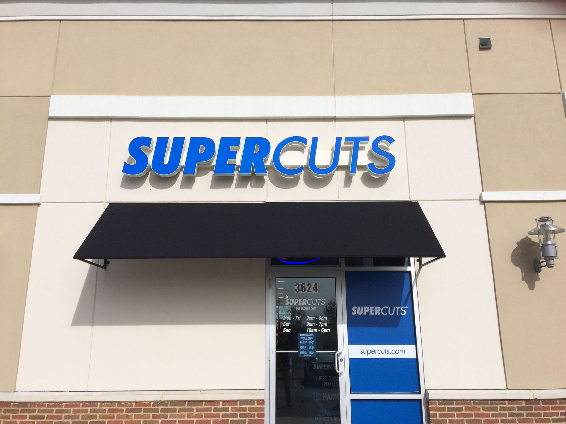 A Supercuts unit with a black awning over the door.