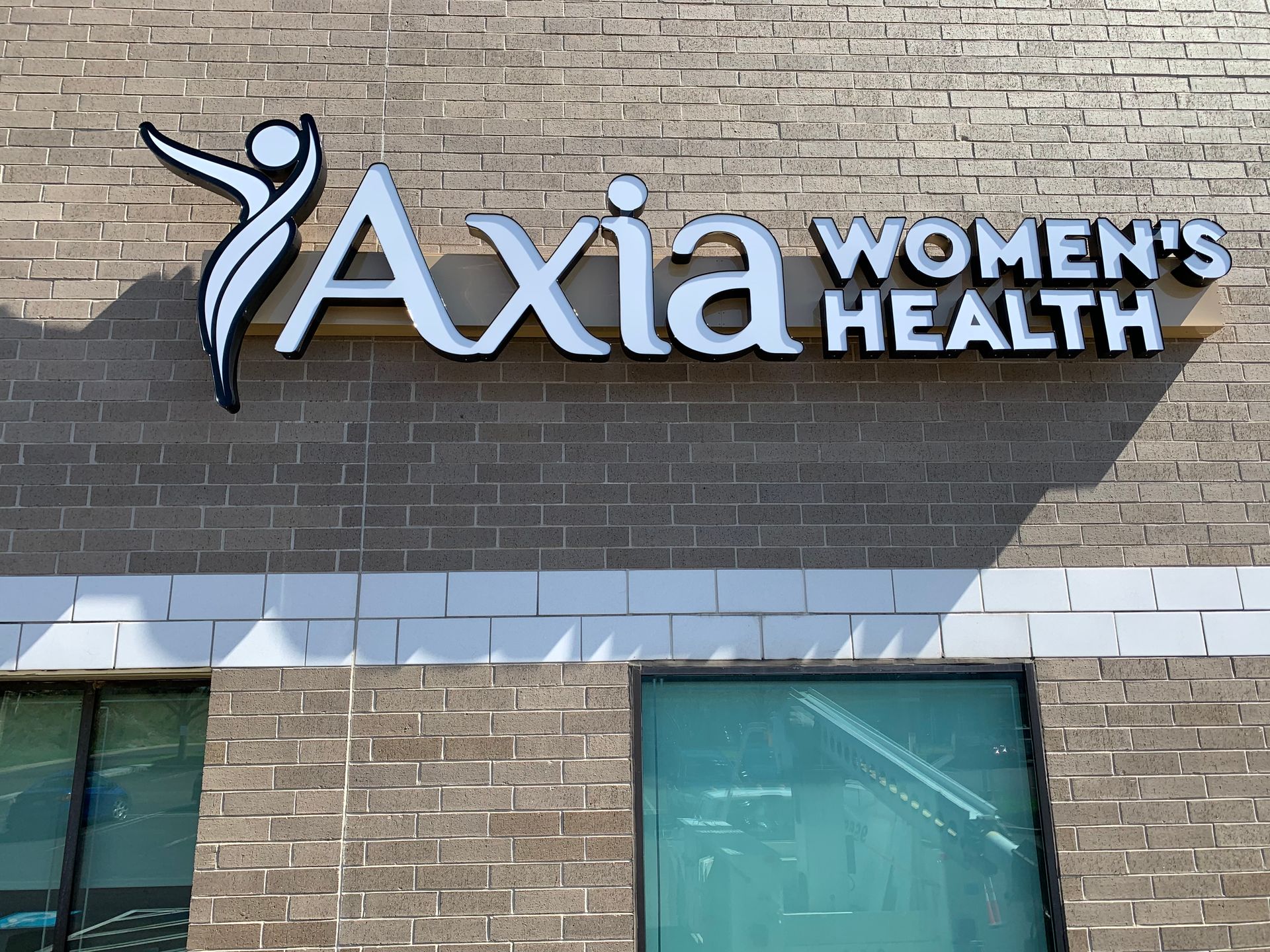 A sign for axia women 's health is on a brick building