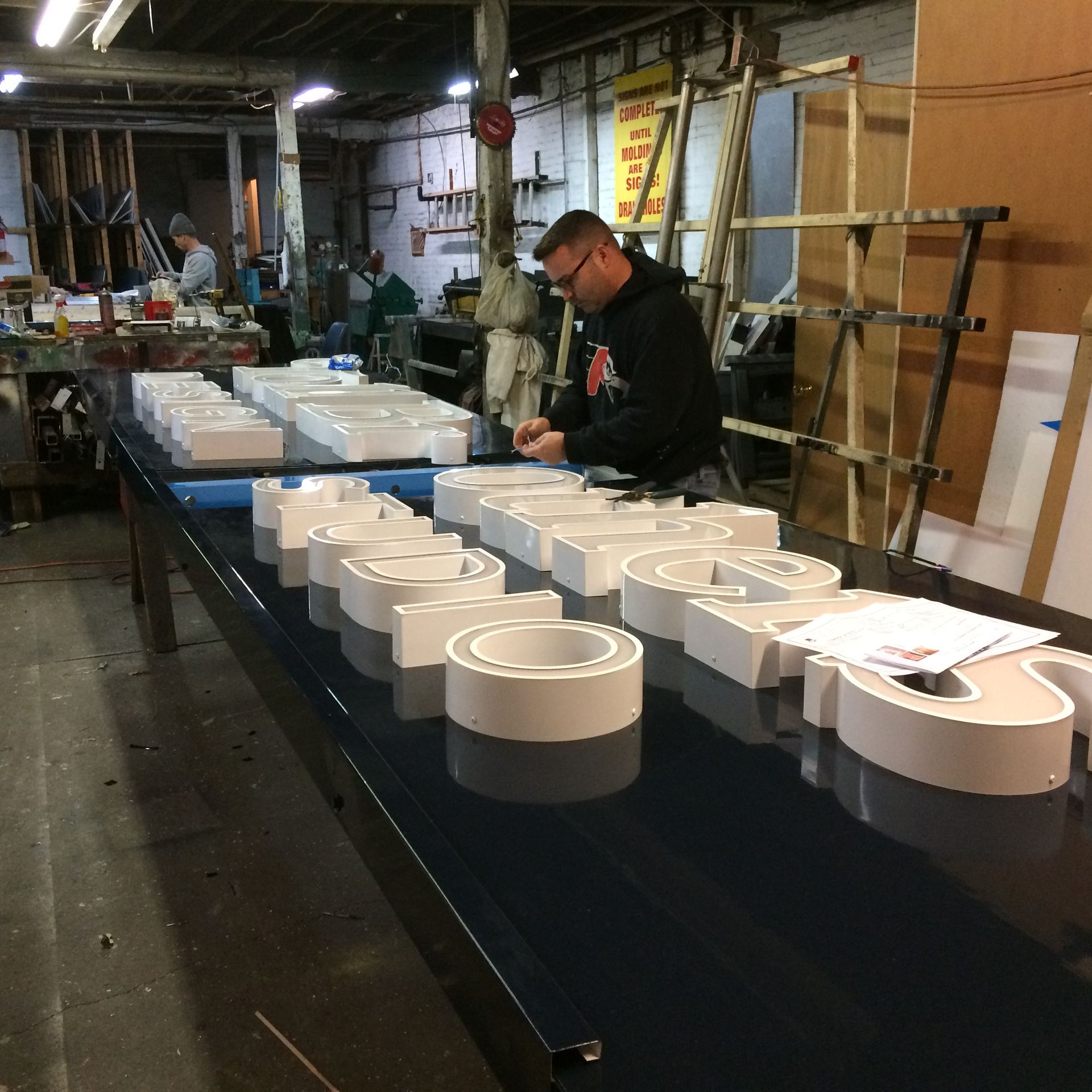 A man sits at a table with a bunch of letters on it