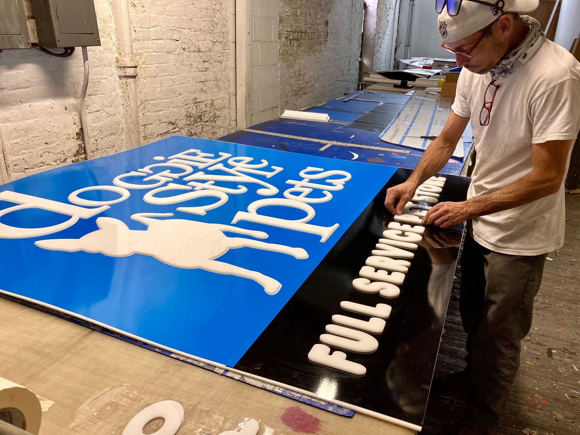 A man is working on a sign that says full service