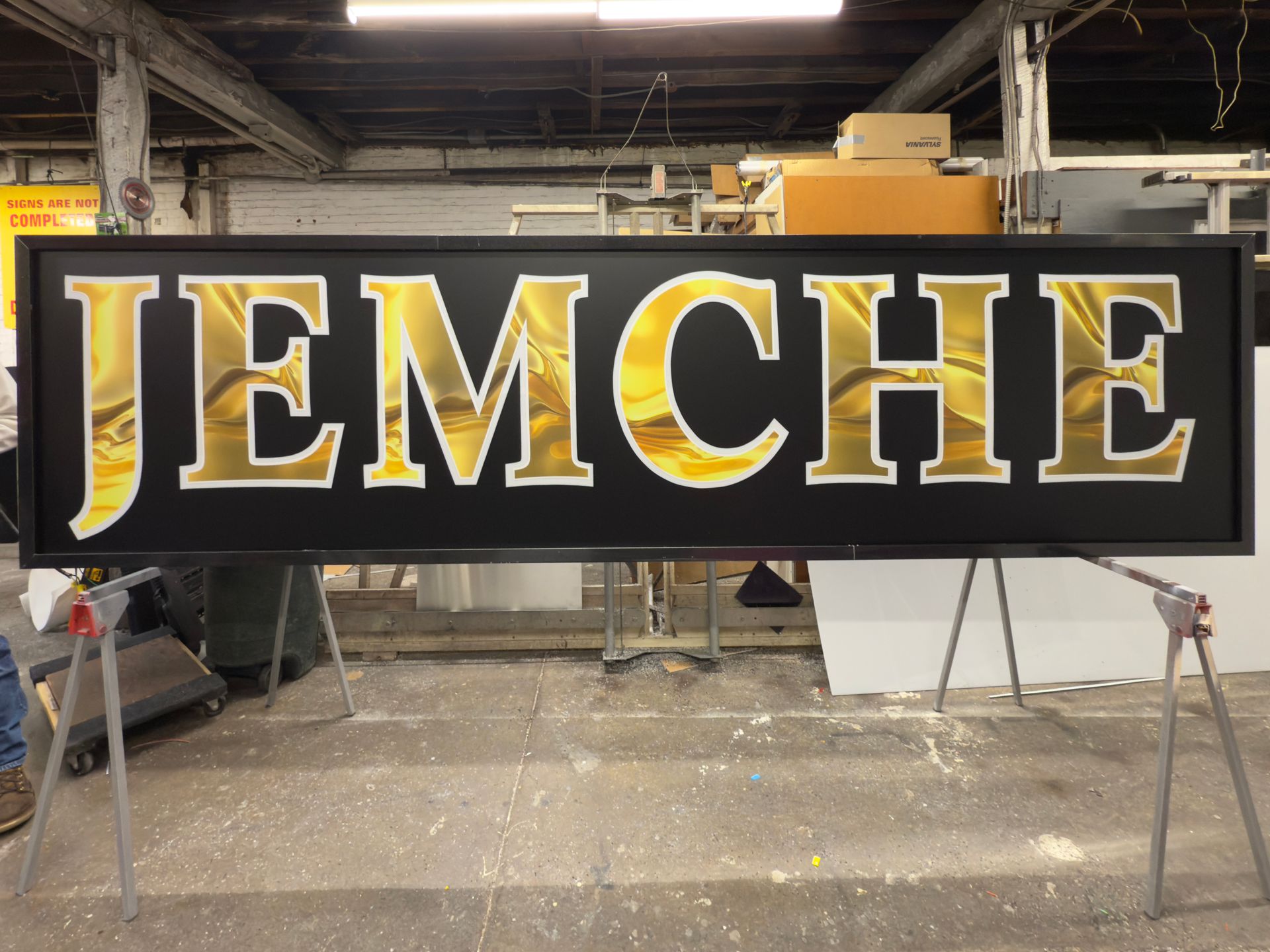 A black sign that says jemche on it