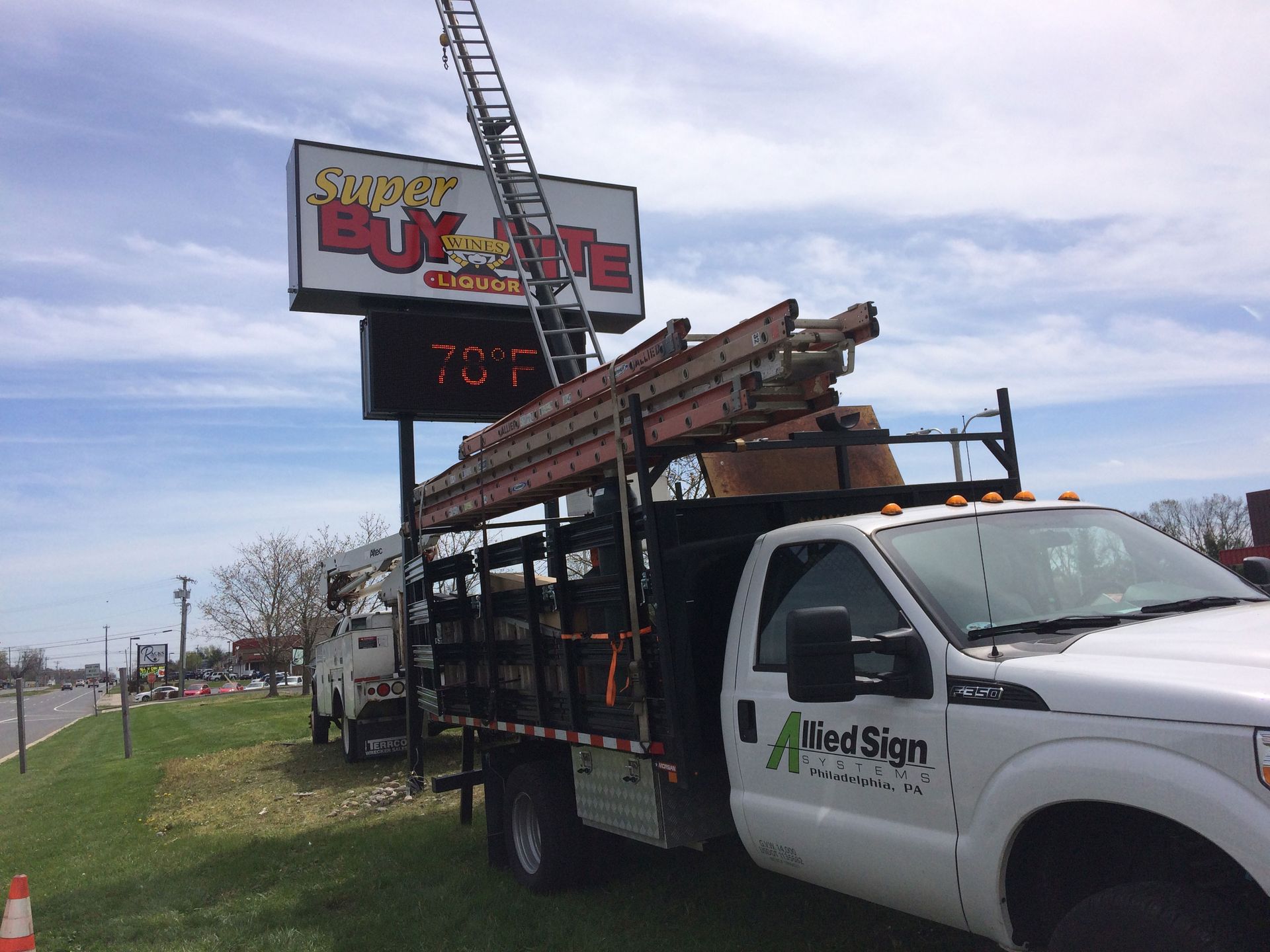 A man wearing yellow gloves is standing in the dirt next to a truck.