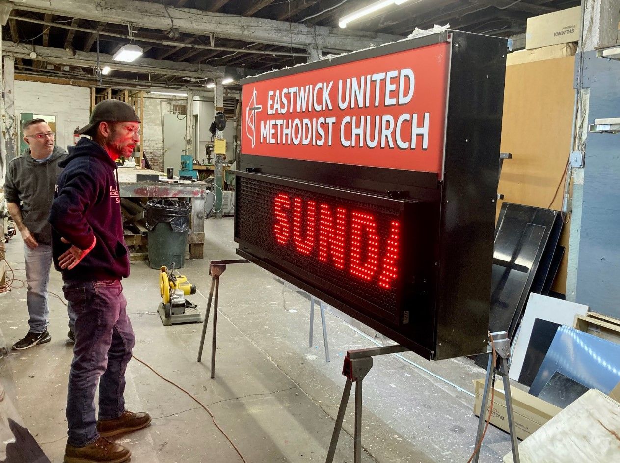 A man is standing in front of a sign that says baltimore united methodist church
