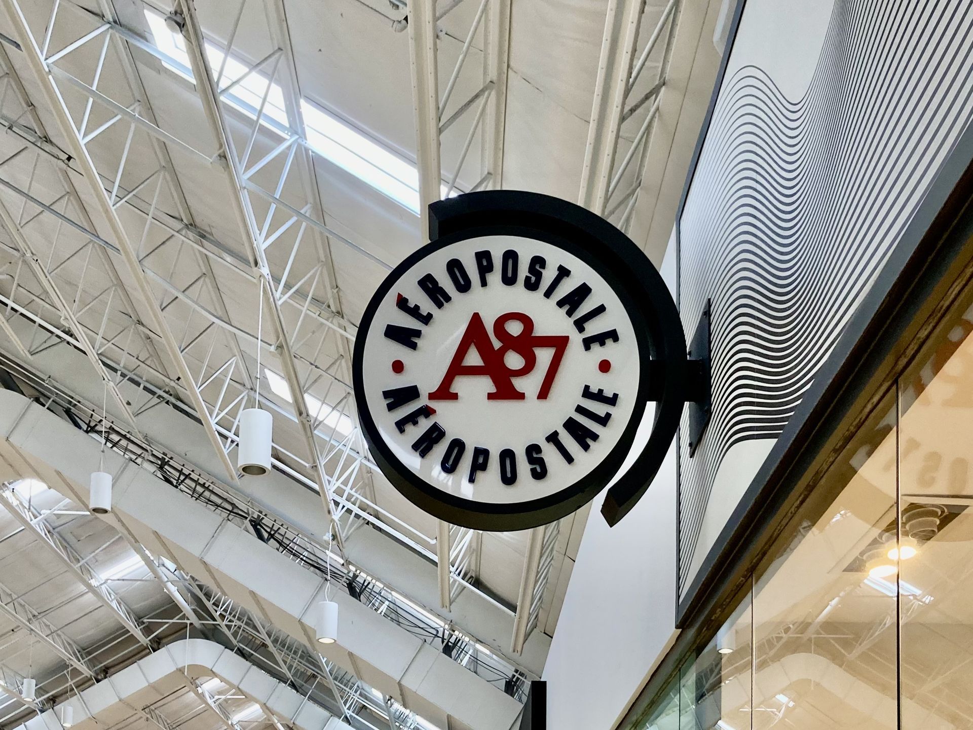 A sign for aeropostale hangs from the ceiling of a building