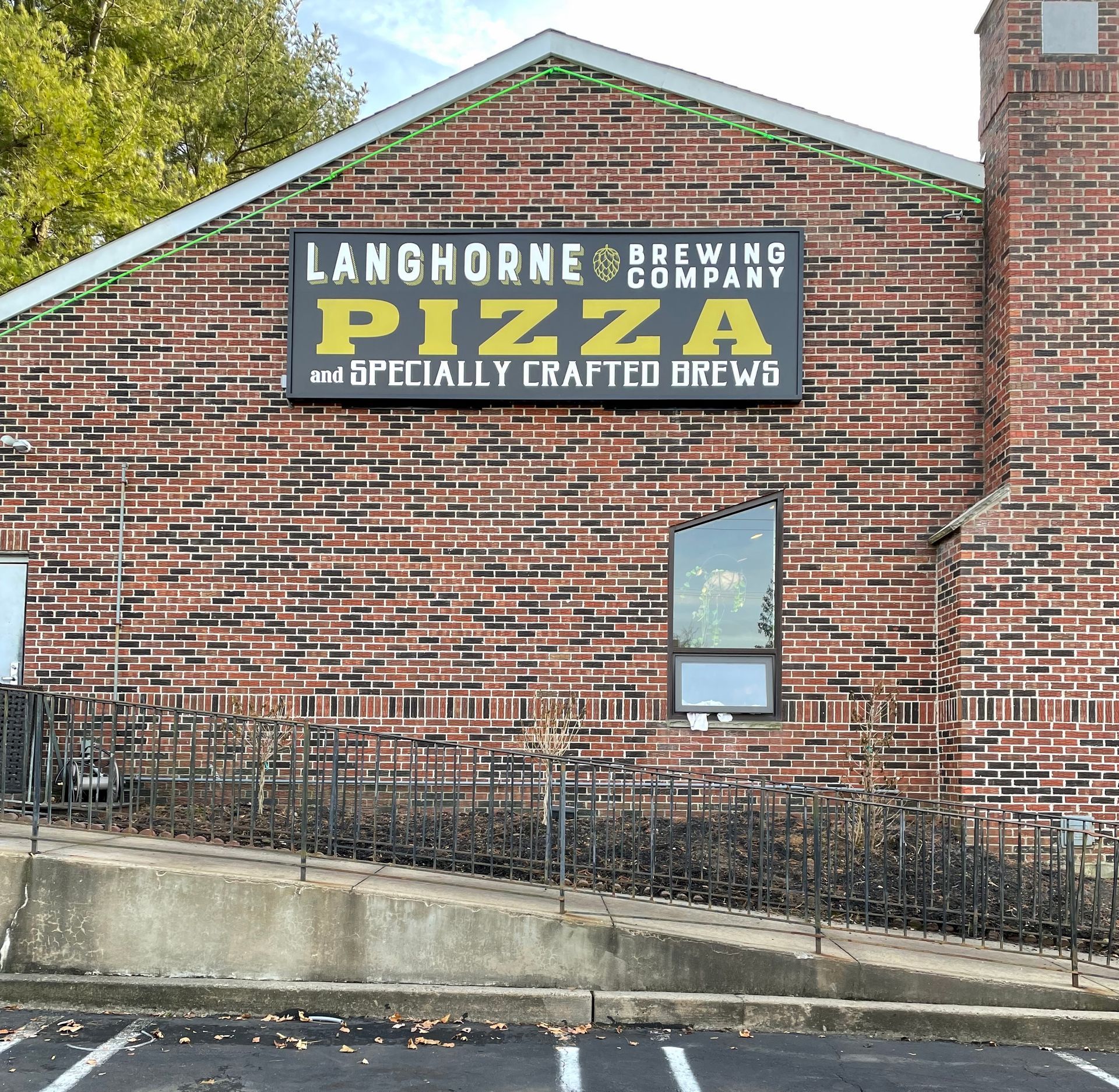 A brick building with a sign that says langhorne pizza