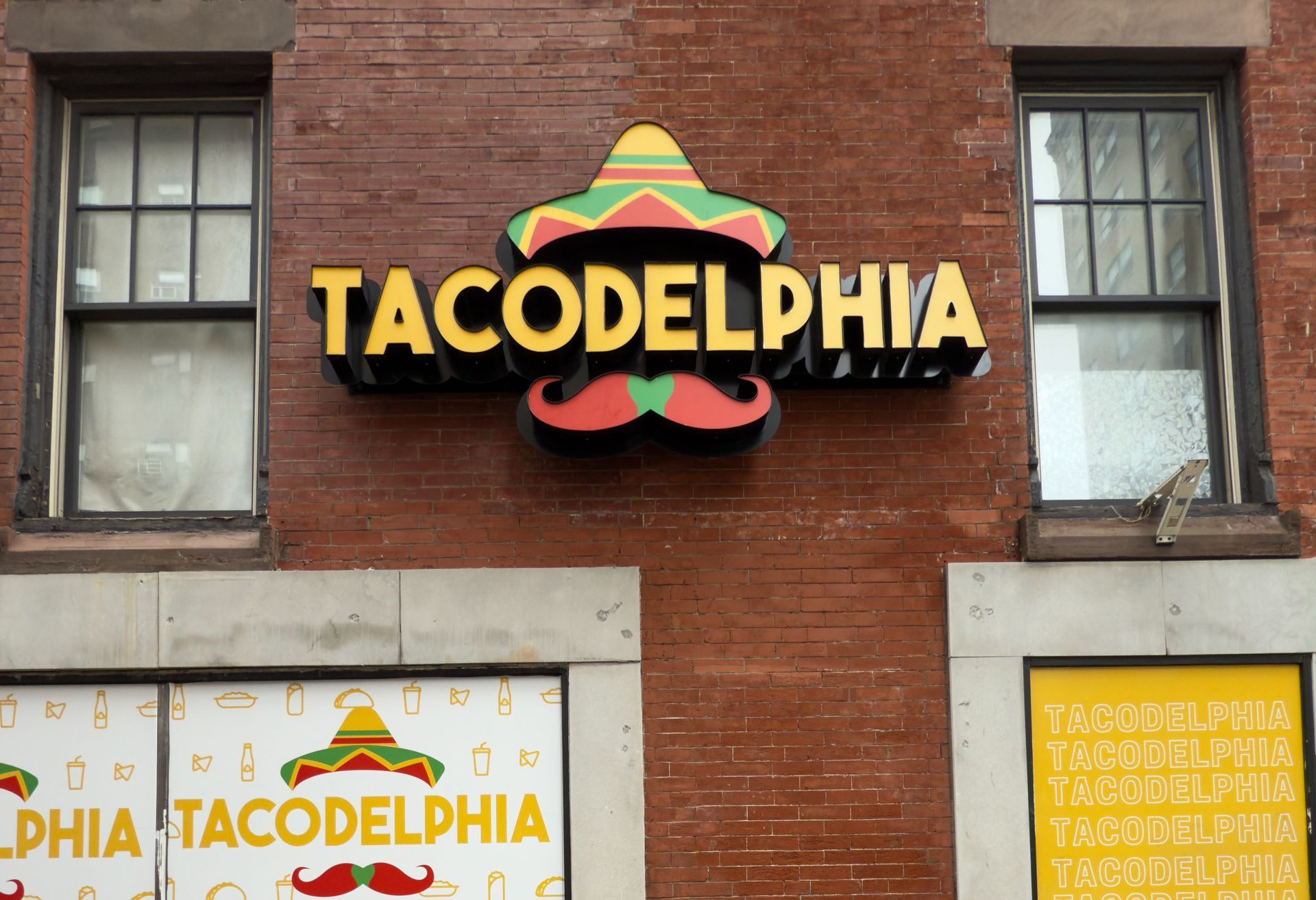 A brick building with a sign that says tacodelphia