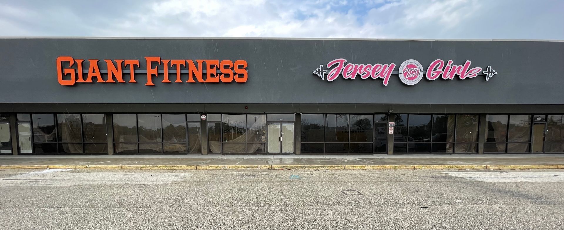 A large building with a lot of windows and a sign that says giant fitness.