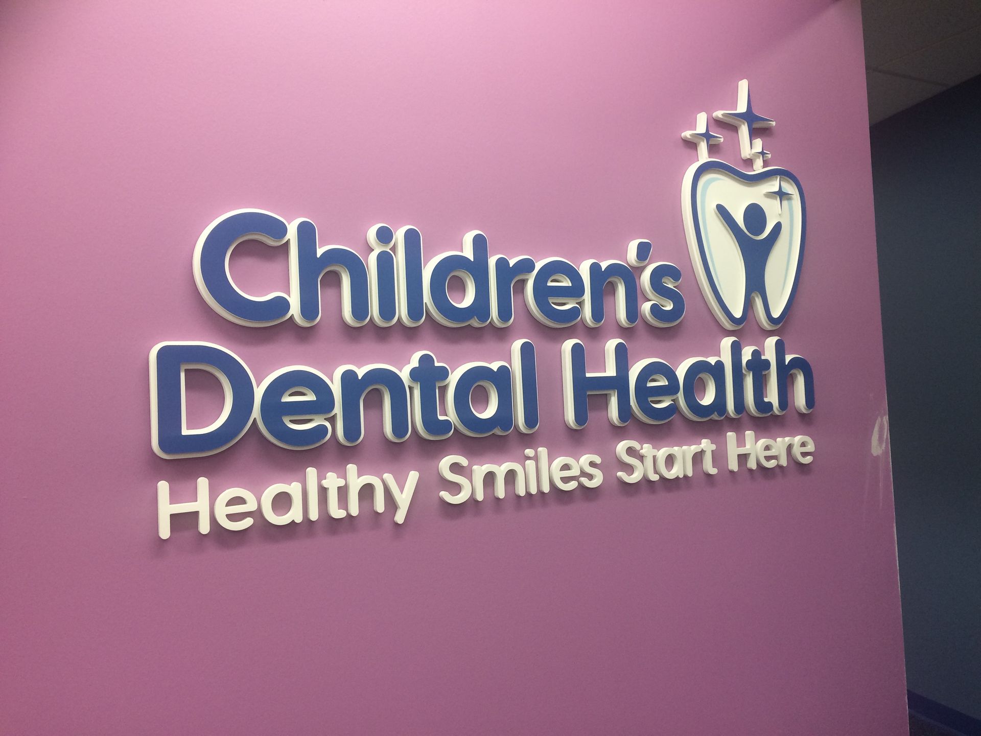 A children 's dental health sign on a pink wall