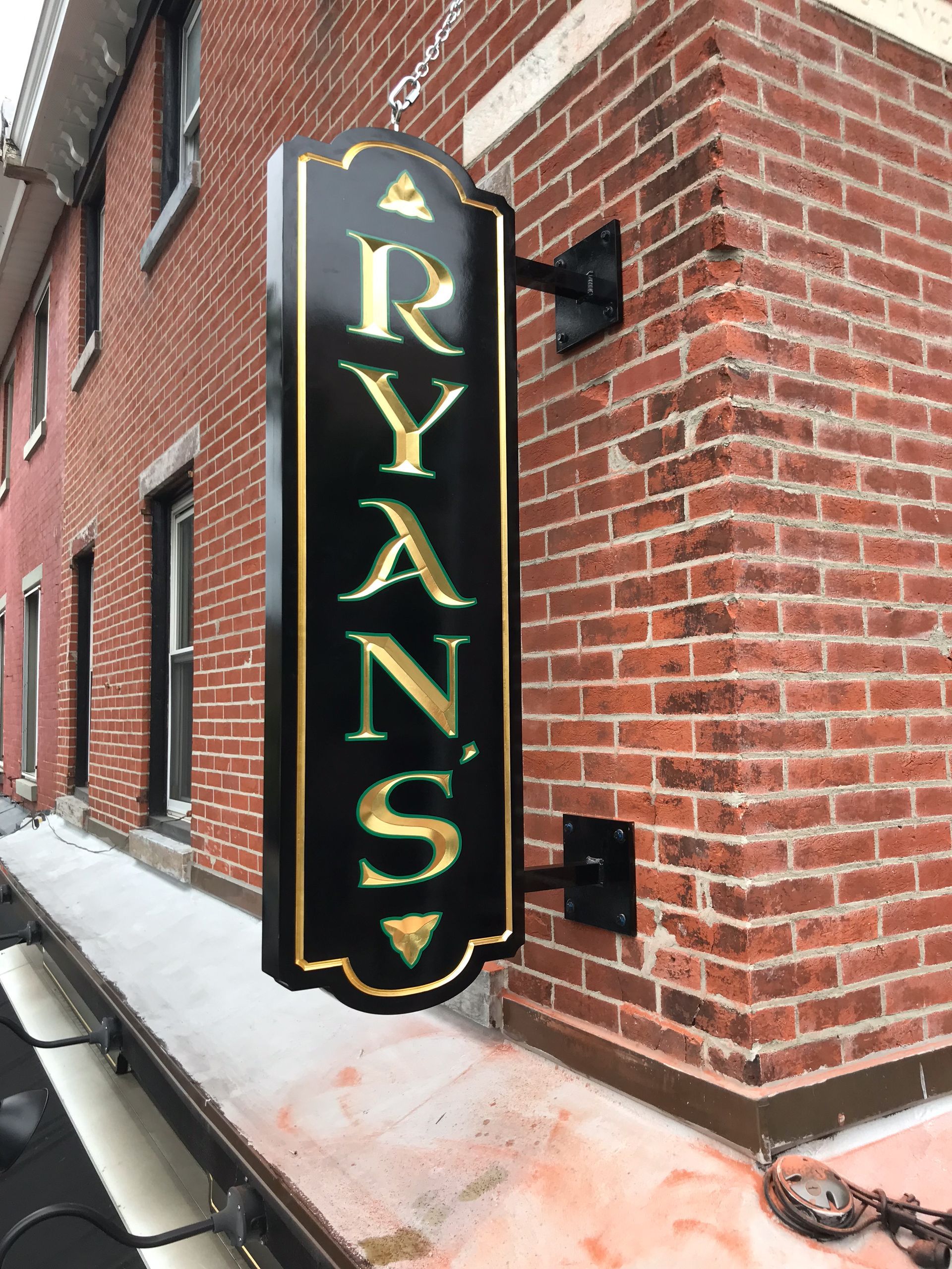 A sign on the side of a brick building says ryan 's