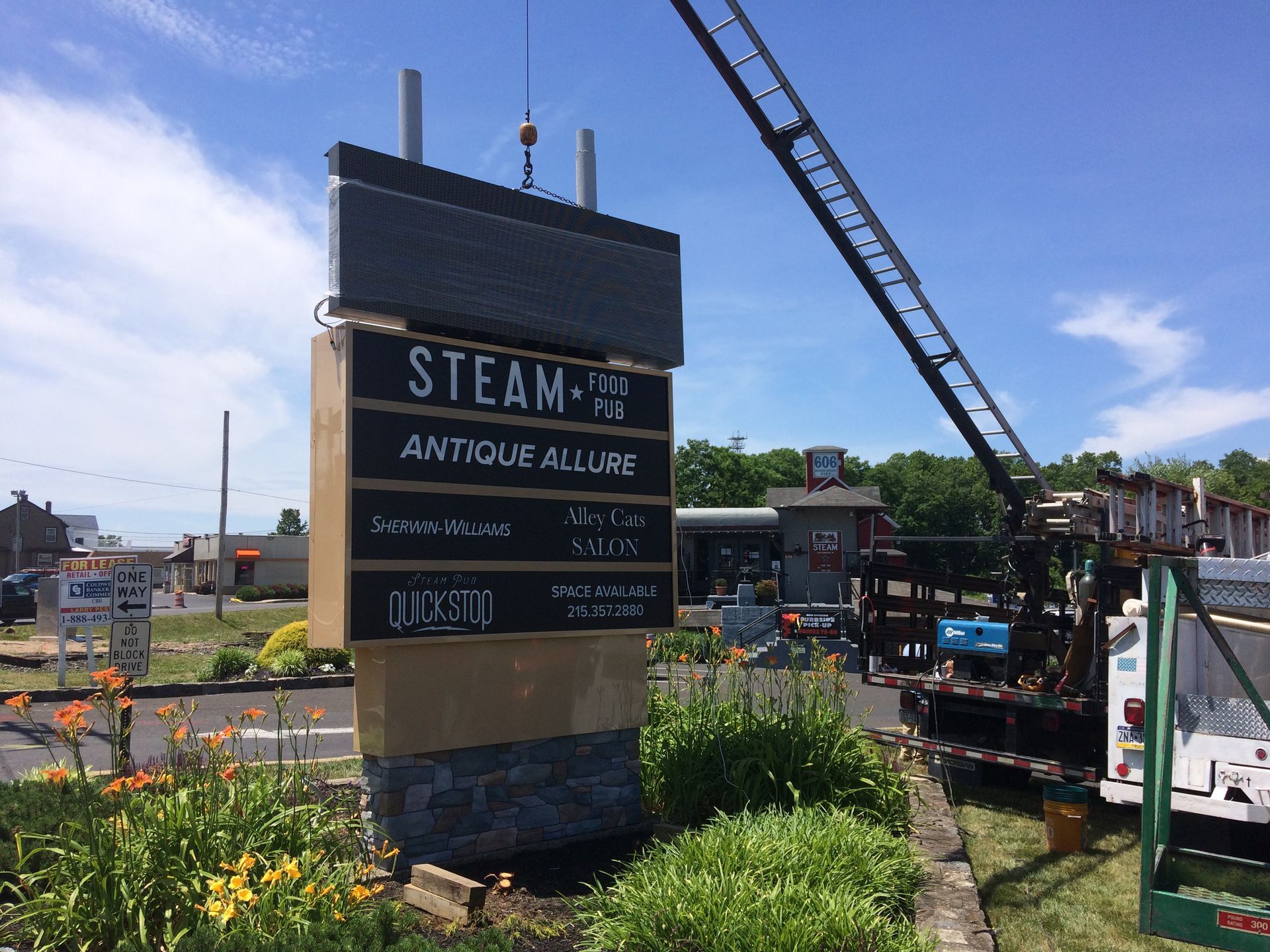 A sign for steam antique allure is being lifted by a crane