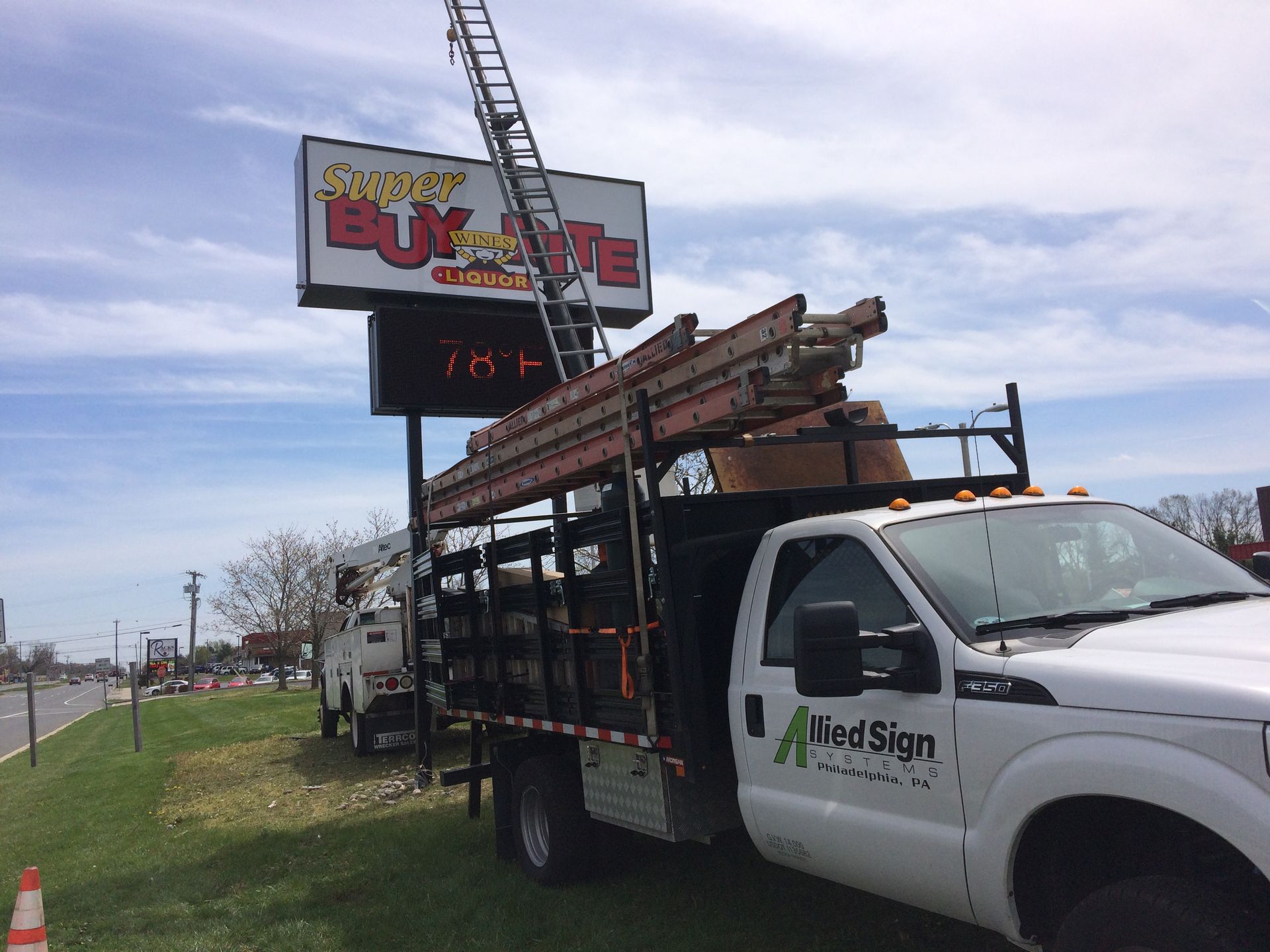 A white truck is parked in front of a sign that says buy a lite