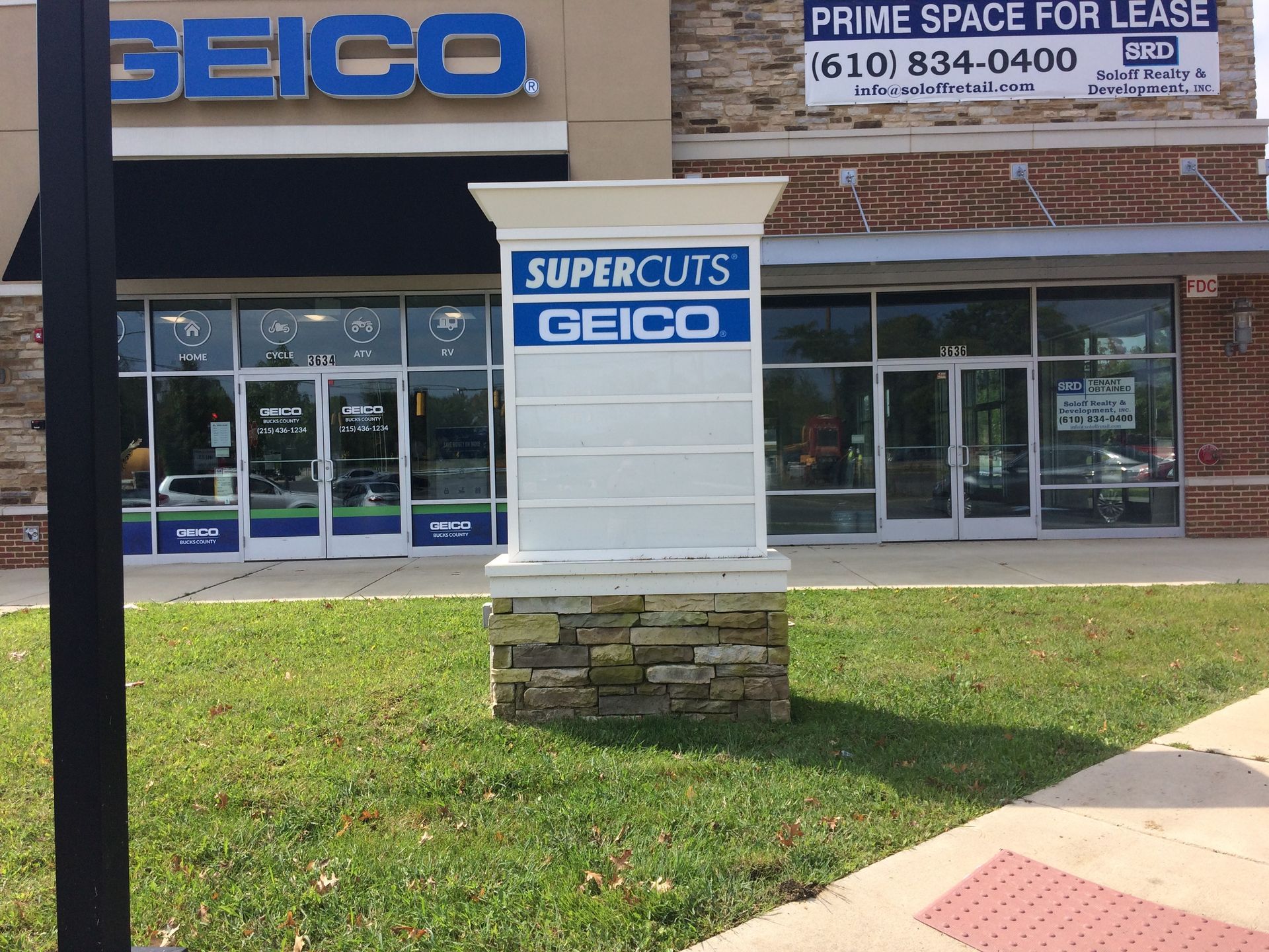 A store front with a sign that says supercuts geico