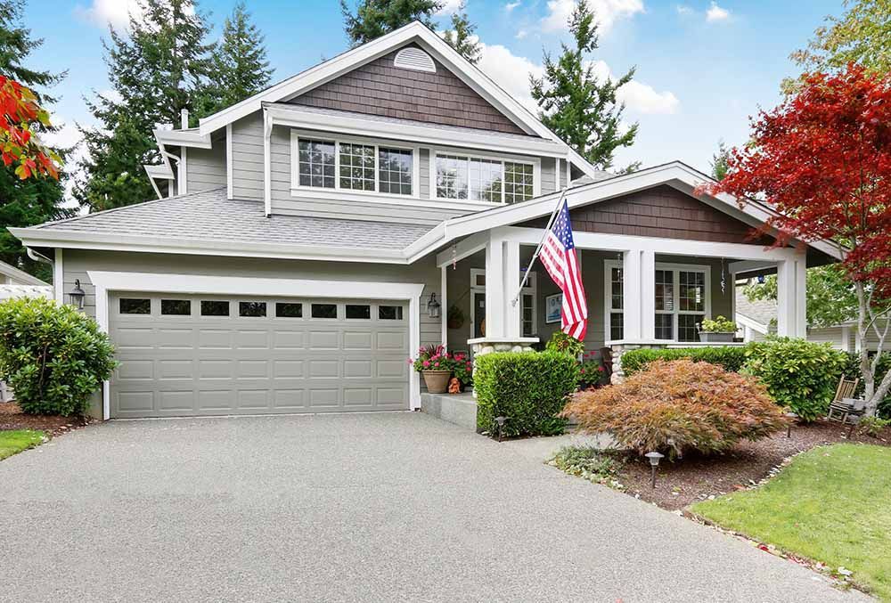 a large house with a garage and an American flag in front of it