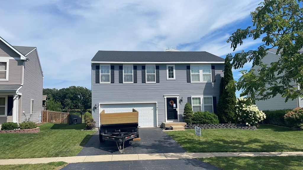 A house with a trailer parked in front of it.
