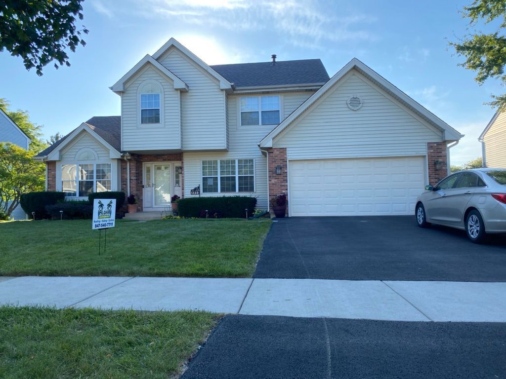 A large white house with a car parked in front of it.