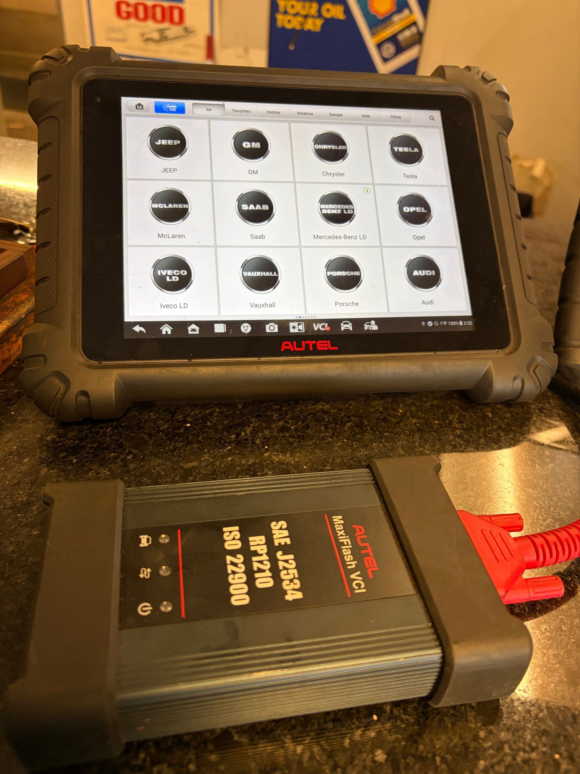 Autel MaxiPRO diagnostic tool on a table, displaying vehicle system options on a tablet screen.