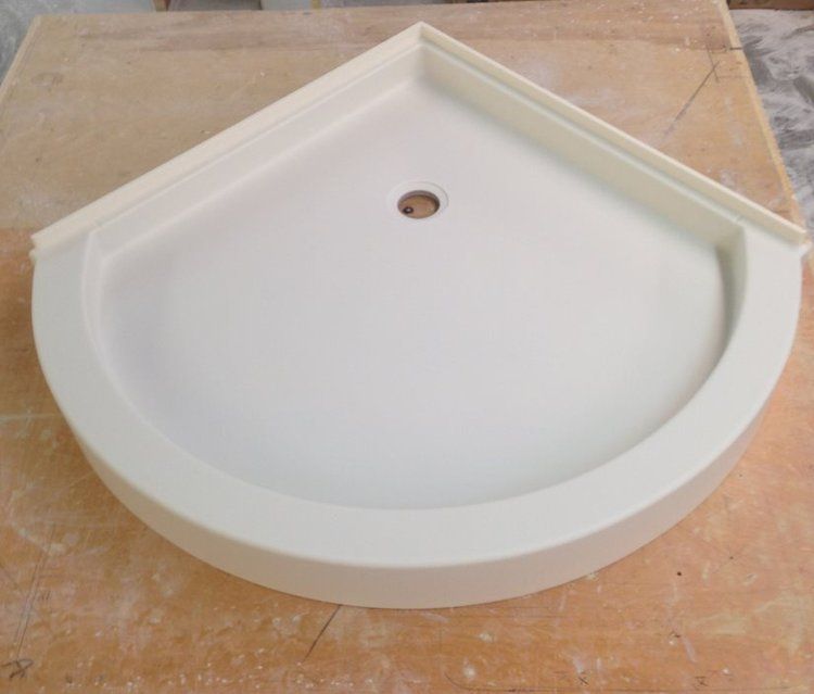 A white sink is sitting on top of a wooden table.