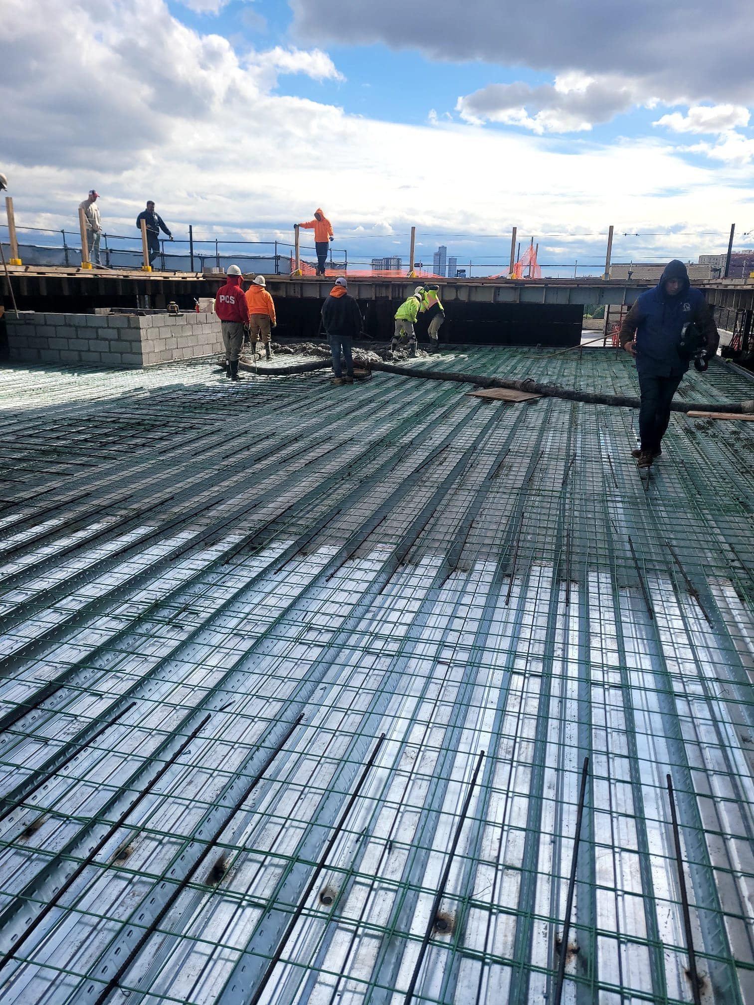 A group of construction workers are working on a concrete floor.
