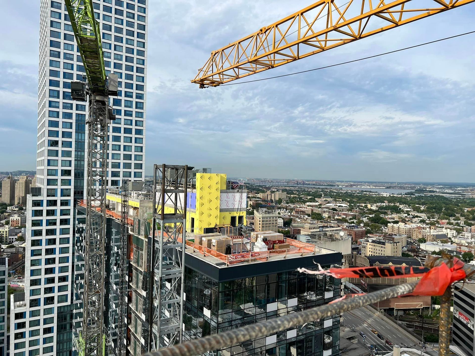 An aerial view of a building under construction with a crane in the foreground.