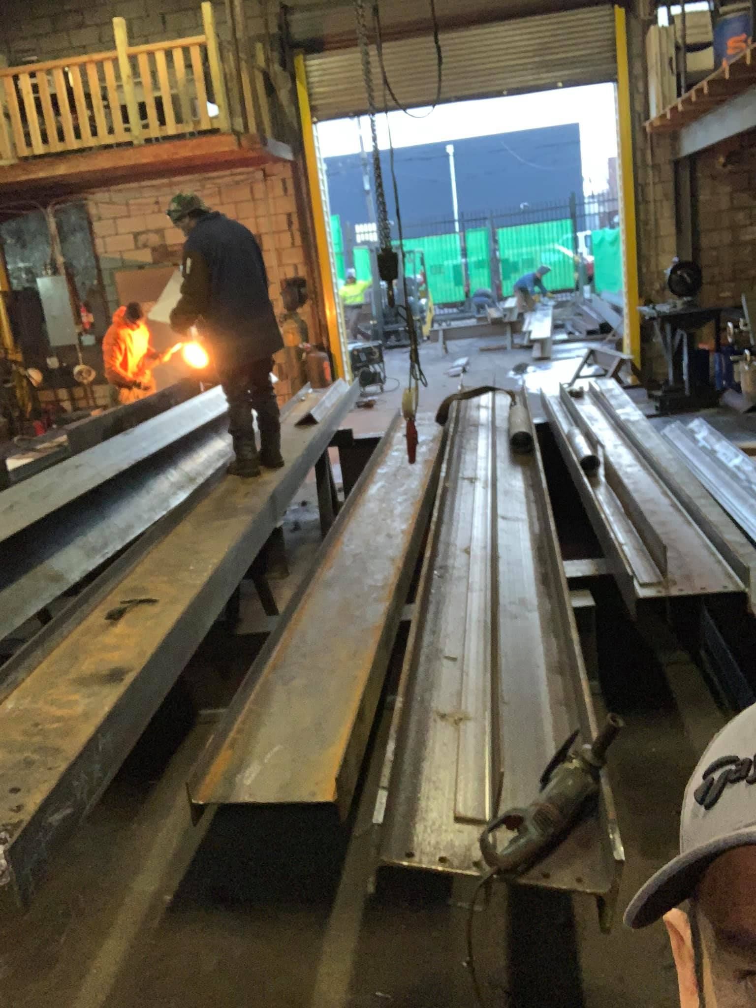 A man is welding a piece of metal in a factory.