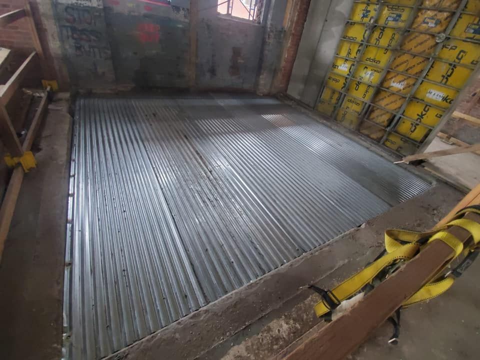 A room with a metal floor and a yellow ladder