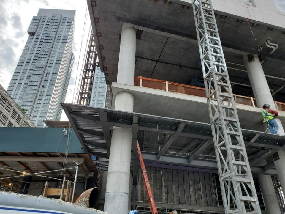 A construction site with a large building in the background