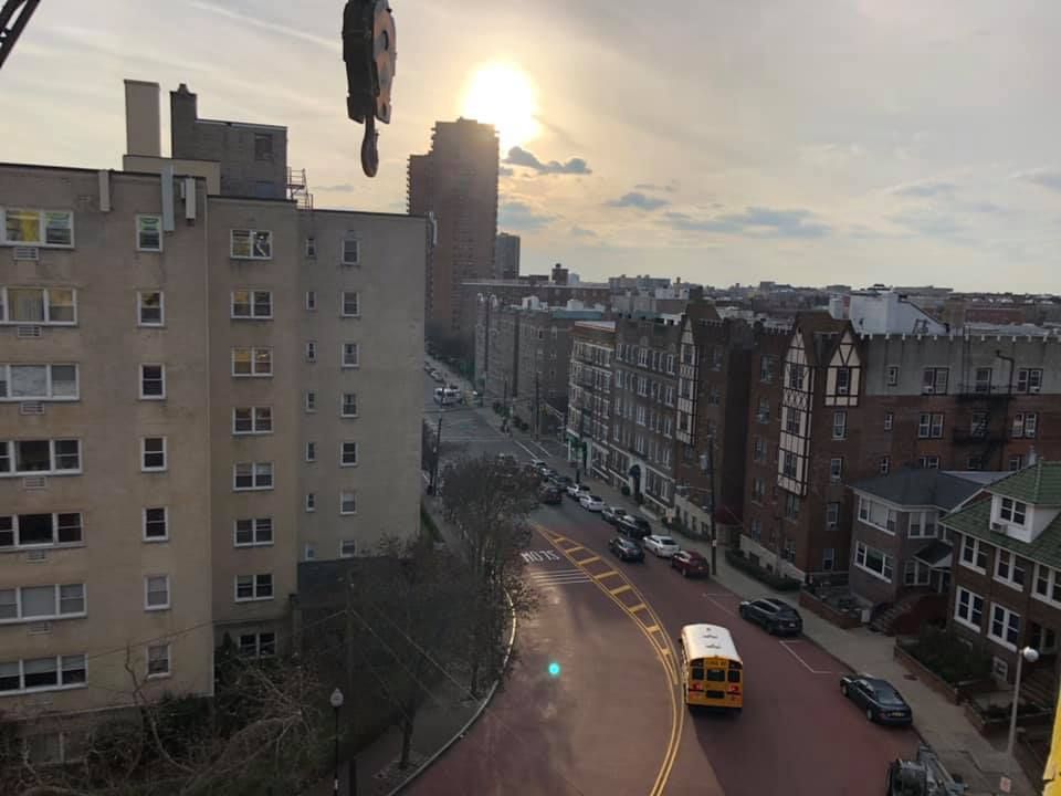 A yellow school bus is driving down a city street