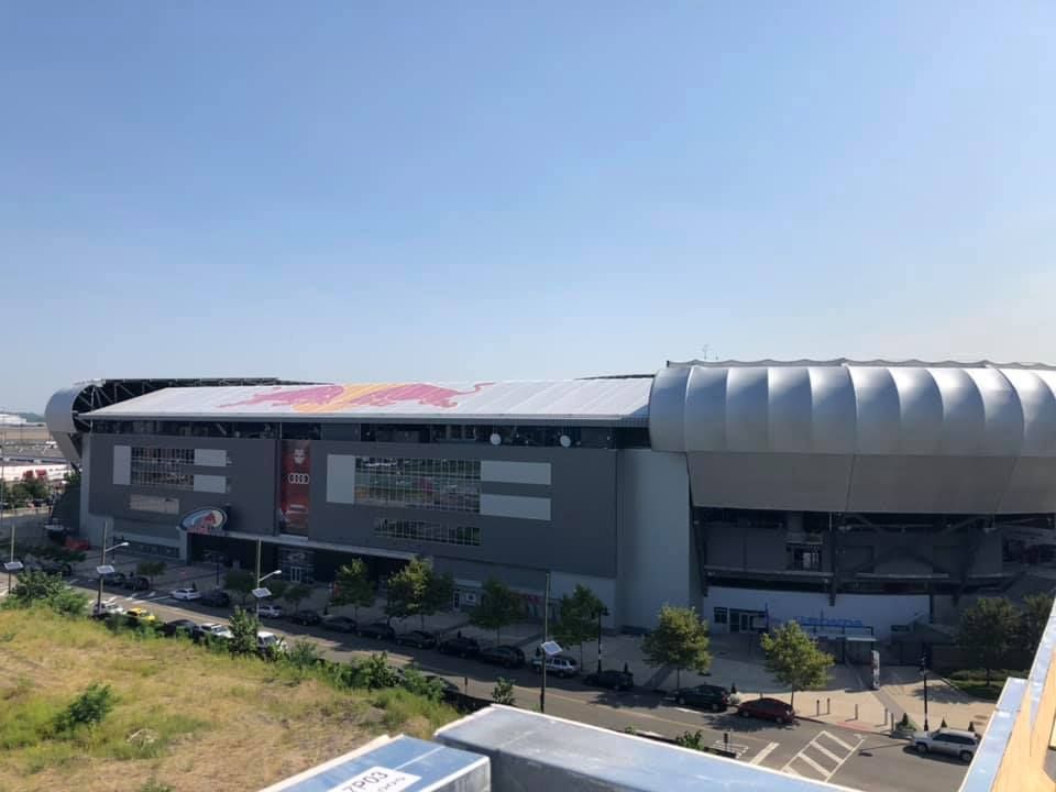 An aerial view of a large building with a red bull logo on the roof.