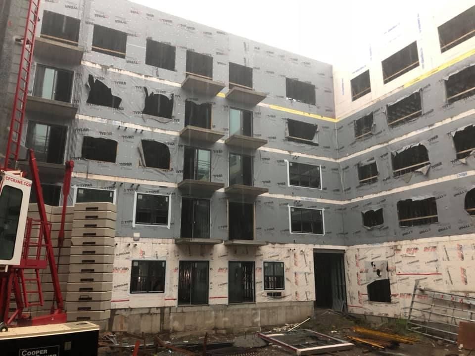 A large building under construction with a crane in front of it.